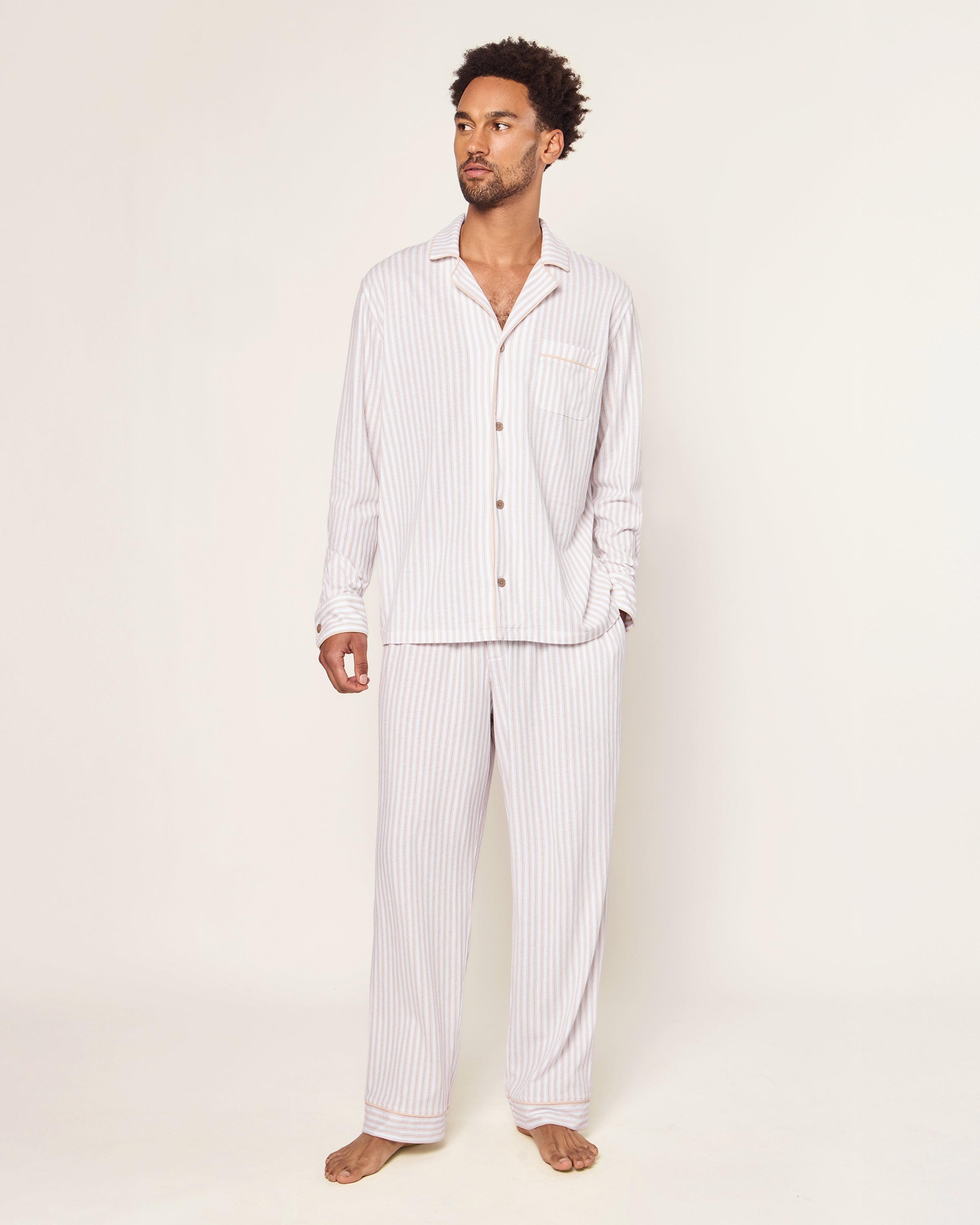 The Men's Pima Pajama Set in Camel Ticking features beige and white stripes, a button-up long-sleeve top with a chest pocket, and matching drawstring pants, displayed flat on a white background.