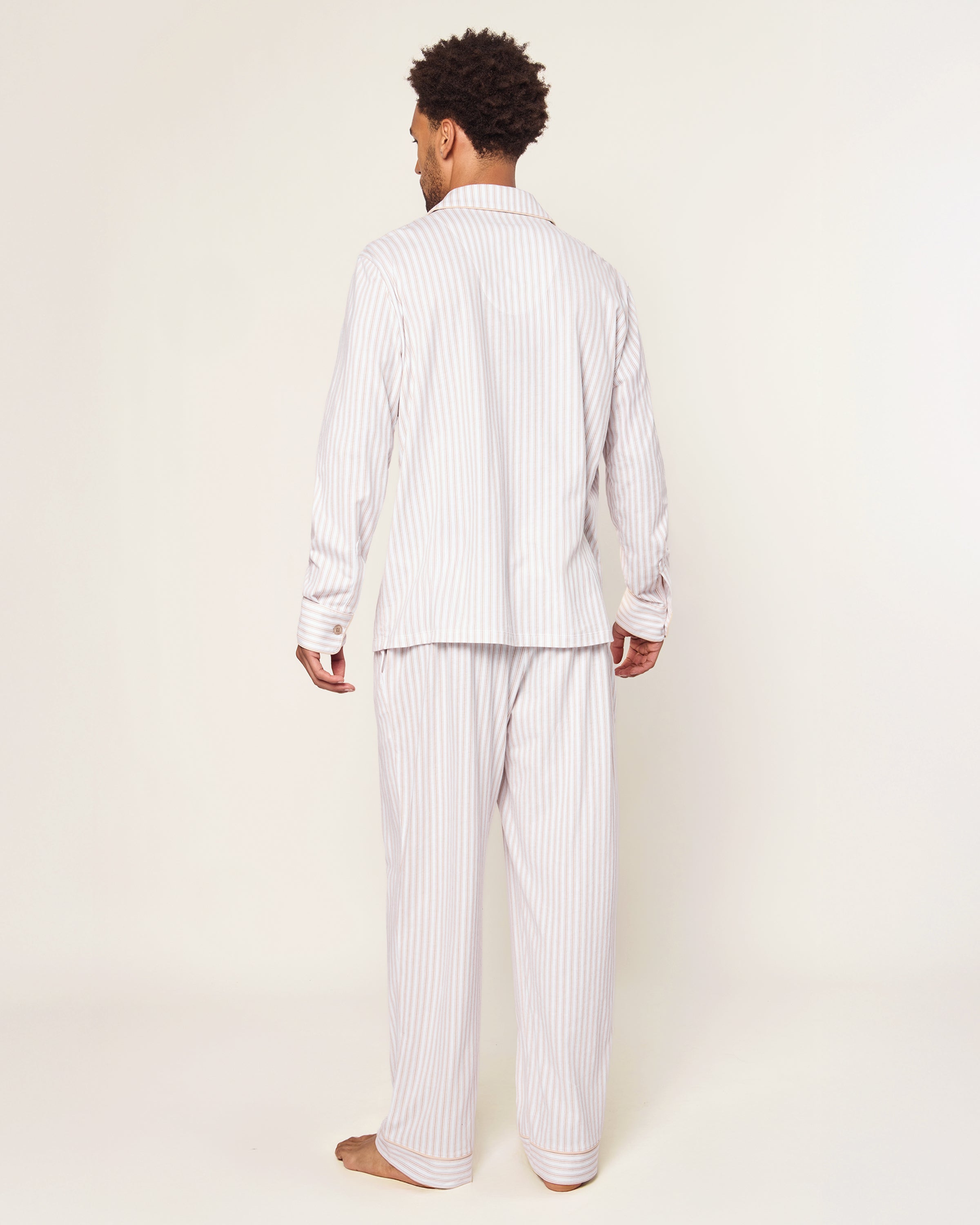 The Men's Pima Pajama Set in Camel Ticking features beige and white stripes, a button-up long-sleeve top with a chest pocket, and matching drawstring pants, displayed flat on a white background.