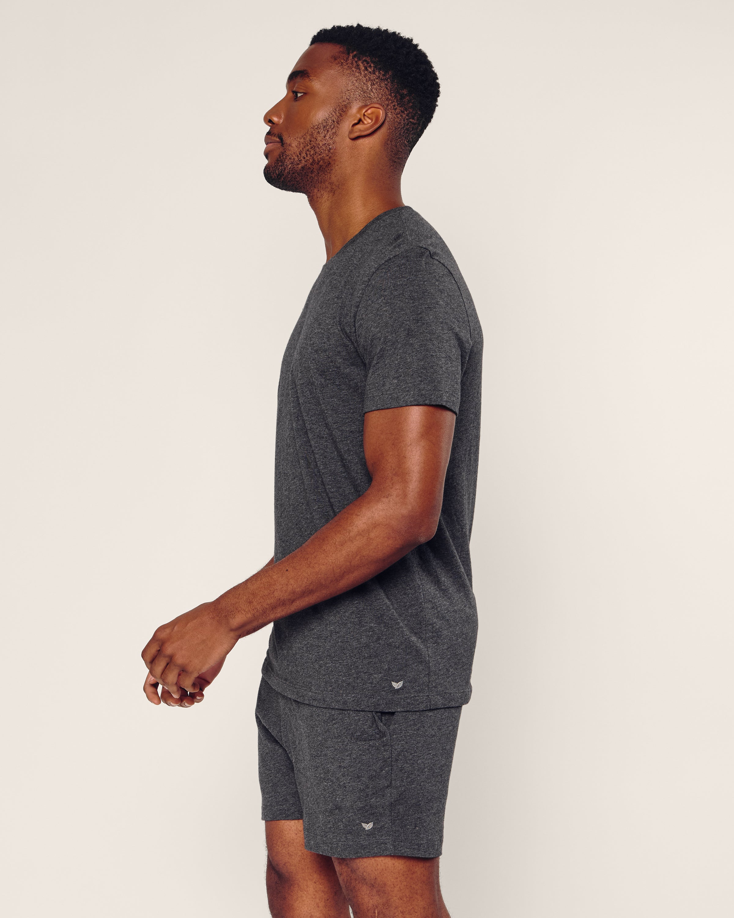 A man stands in profile against a plain background, wearing Petite Plumes Mens 5 Pima Short in Dark Heather Grey, crafted from luxurious pajamas-quality Peruvian Pima cotton.