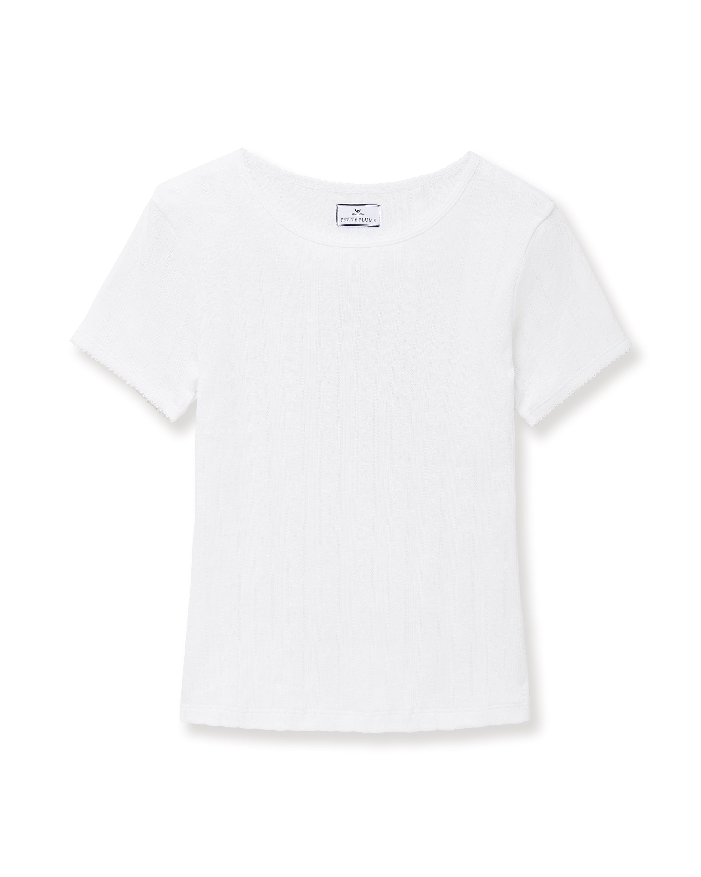 A woman with long brown hair wears the Women's Pointelle T-Shirt in White, standing against a plain light background and smiling gently at the camera.