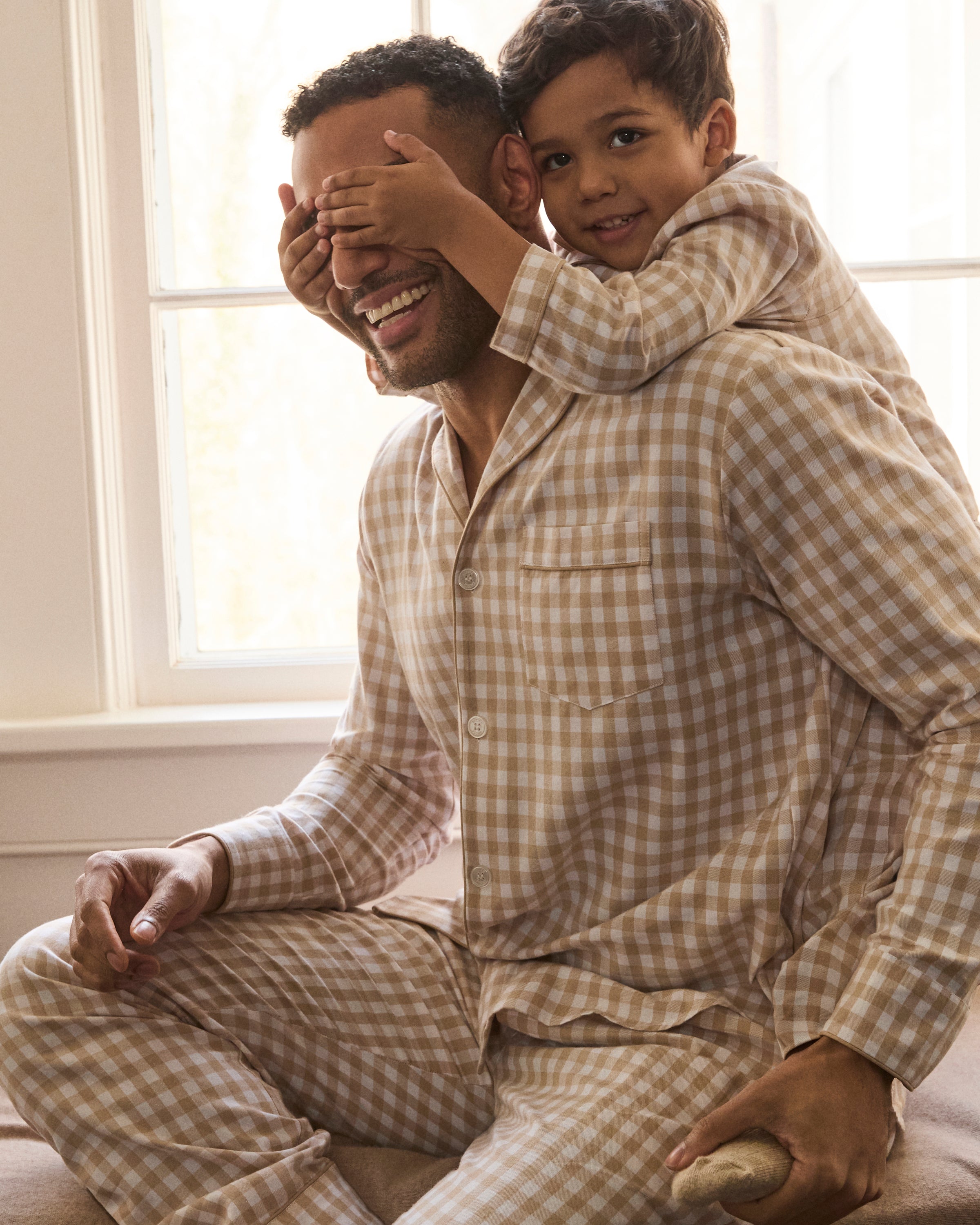 The Men's Twill Pajama Set in Camel Gingham includes a long-sleeve, button-up top with a chest pocket and matching pants, both in a beige and white gingham check pattern.