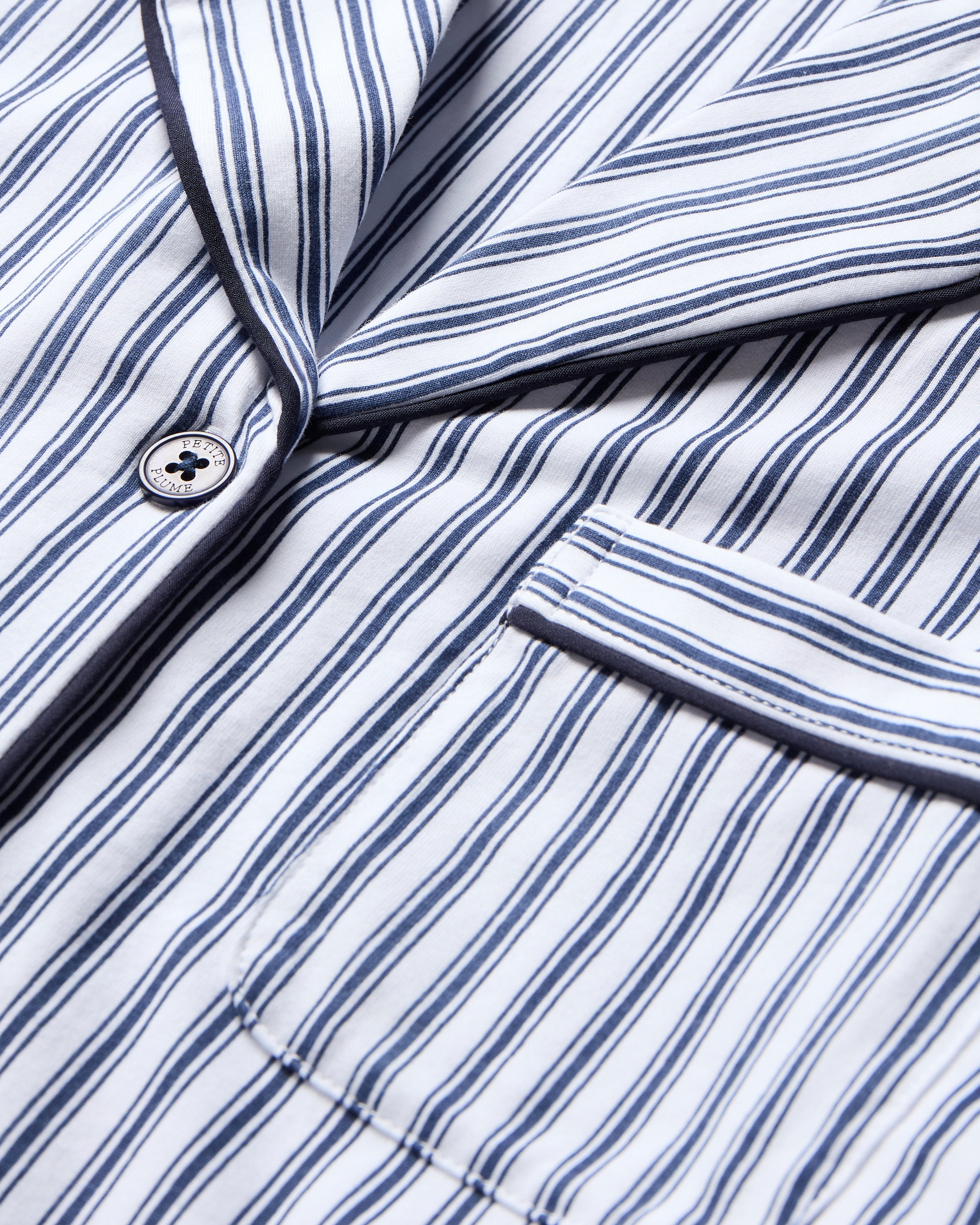 The Women's Pima Crop Pajama Set in Navy French Ticking features a blue and white vertical stripe design, short sleeves, a collared button-up top with chest pocket, and matching long pants.