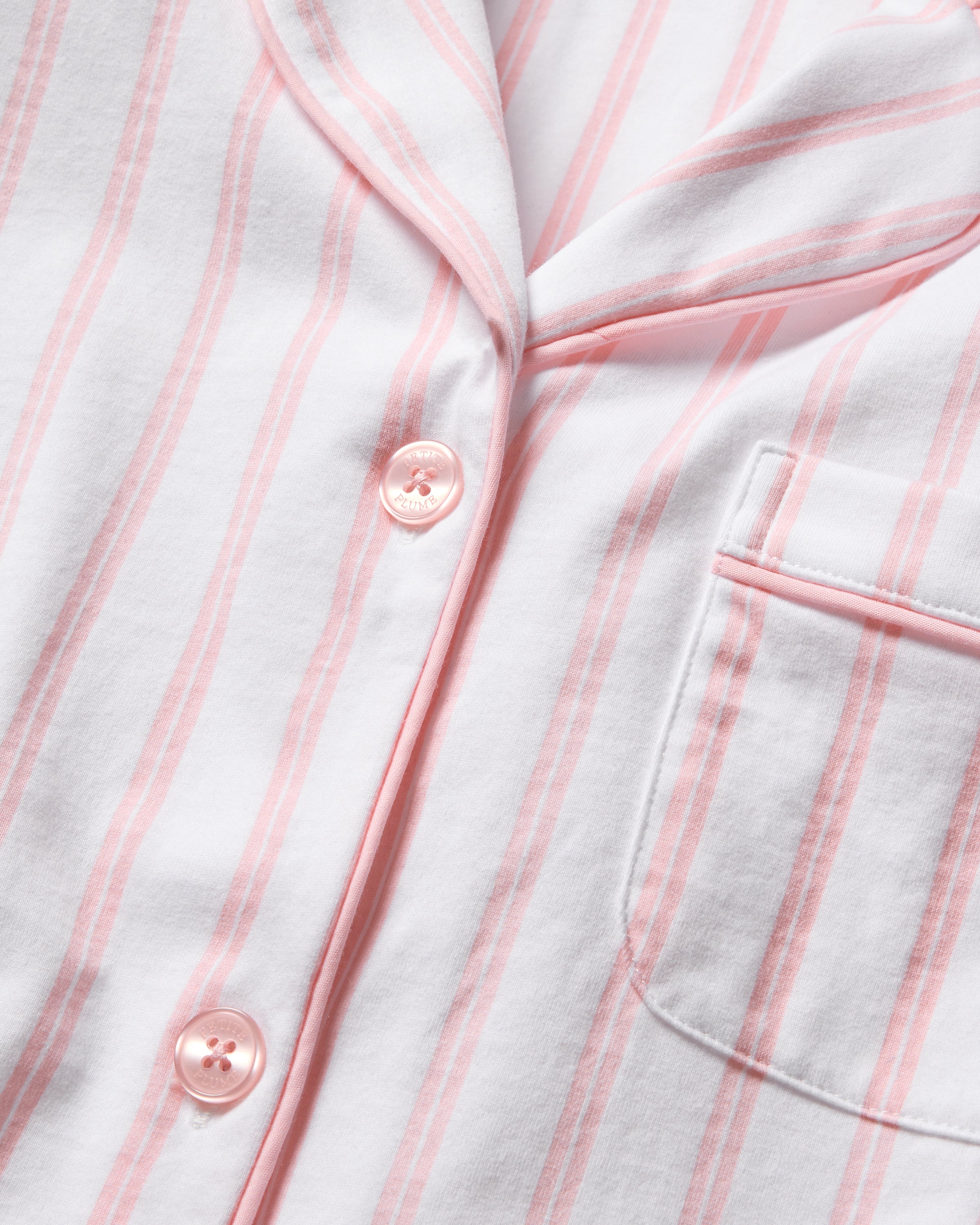 Close-up of Petite Plumes Womens Pima Crop Set in Pink and White Stripe, showcasing a collared shirt design with pink buttons and a right pocket. Made from soft Pima cotton, it exudes a cozy texture perfect for breathable sleepwear.