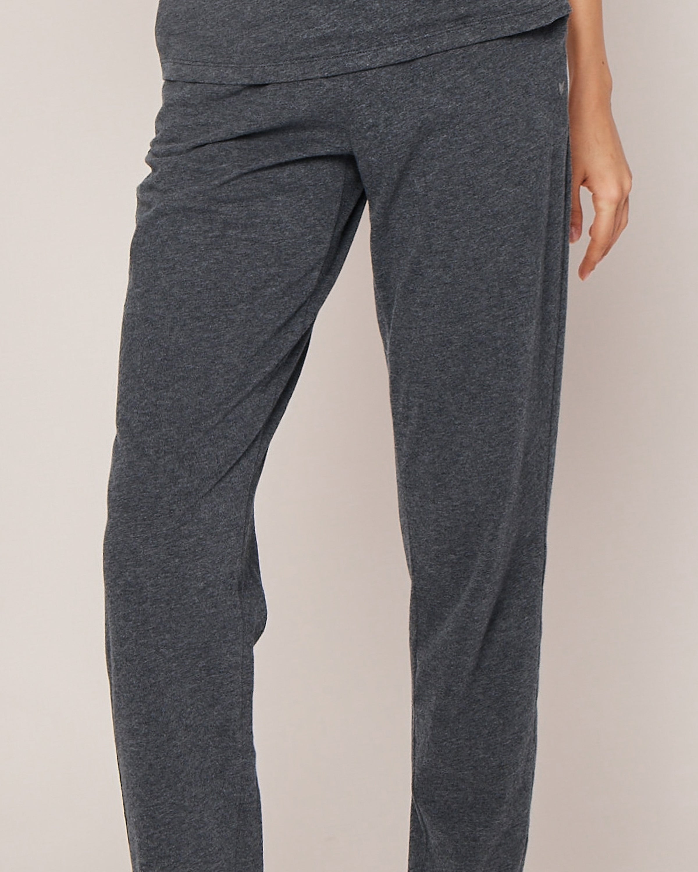 A person in Petite Plumes Womens Pima Lounge Pants in Dark Heather Grey stands against a light background, hand by their side. Only the lower body is visible, highlighting the elegance of our Pima Collection crafted from 100% Peruvian Pima cotton.