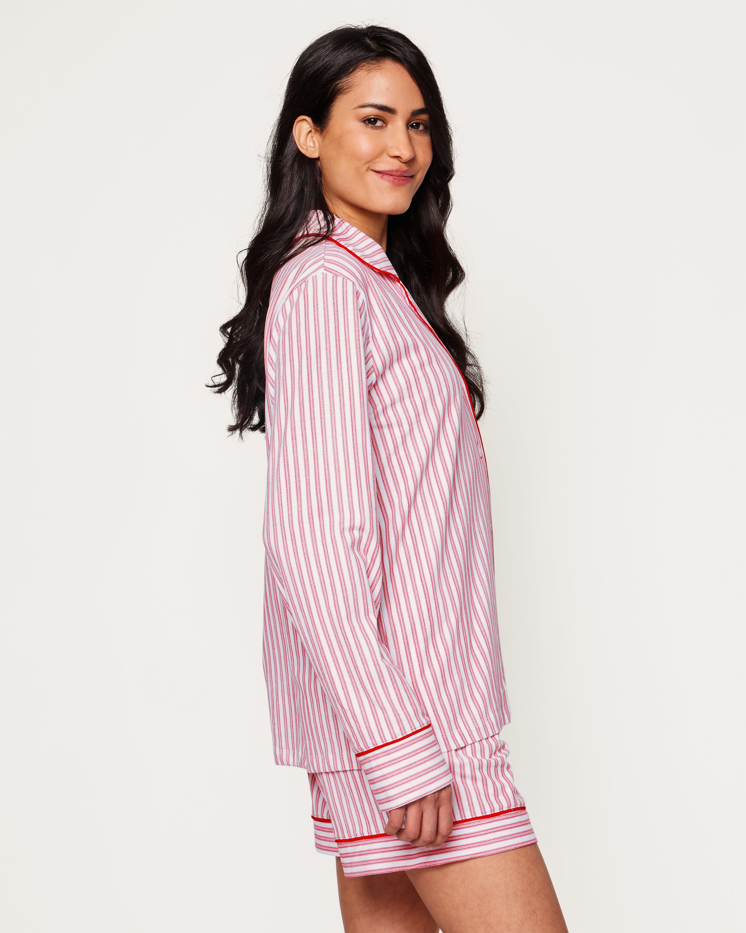 Close-up of Petite Plumes Womens Pima Long Sleeve Short Set in Antique Red Ticking. Crafted from luxurious Pima cotton with vertical red and white stripes, it features tailored piping on the collar and pocket, and a single white button exemplifying sleepwear elegance.