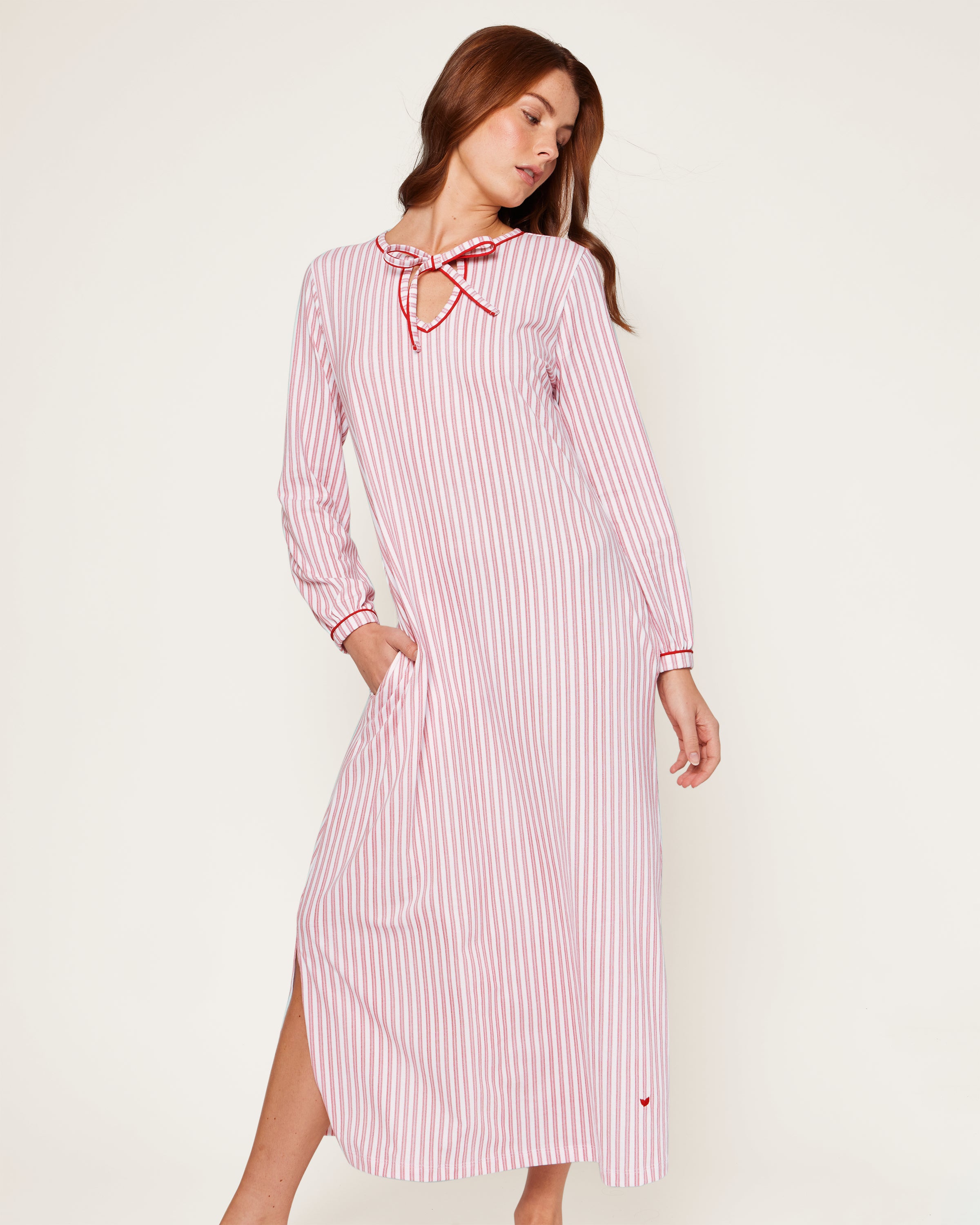 A close-up of the Womens Pima Harlow Nightgown in Antique Red Ticking showcases a red and white striped pattern, made from premium Peruvian Pima cotton. It features a keyhole neckline tied with matching fabric laces, with the Petite Plume label visible on top.