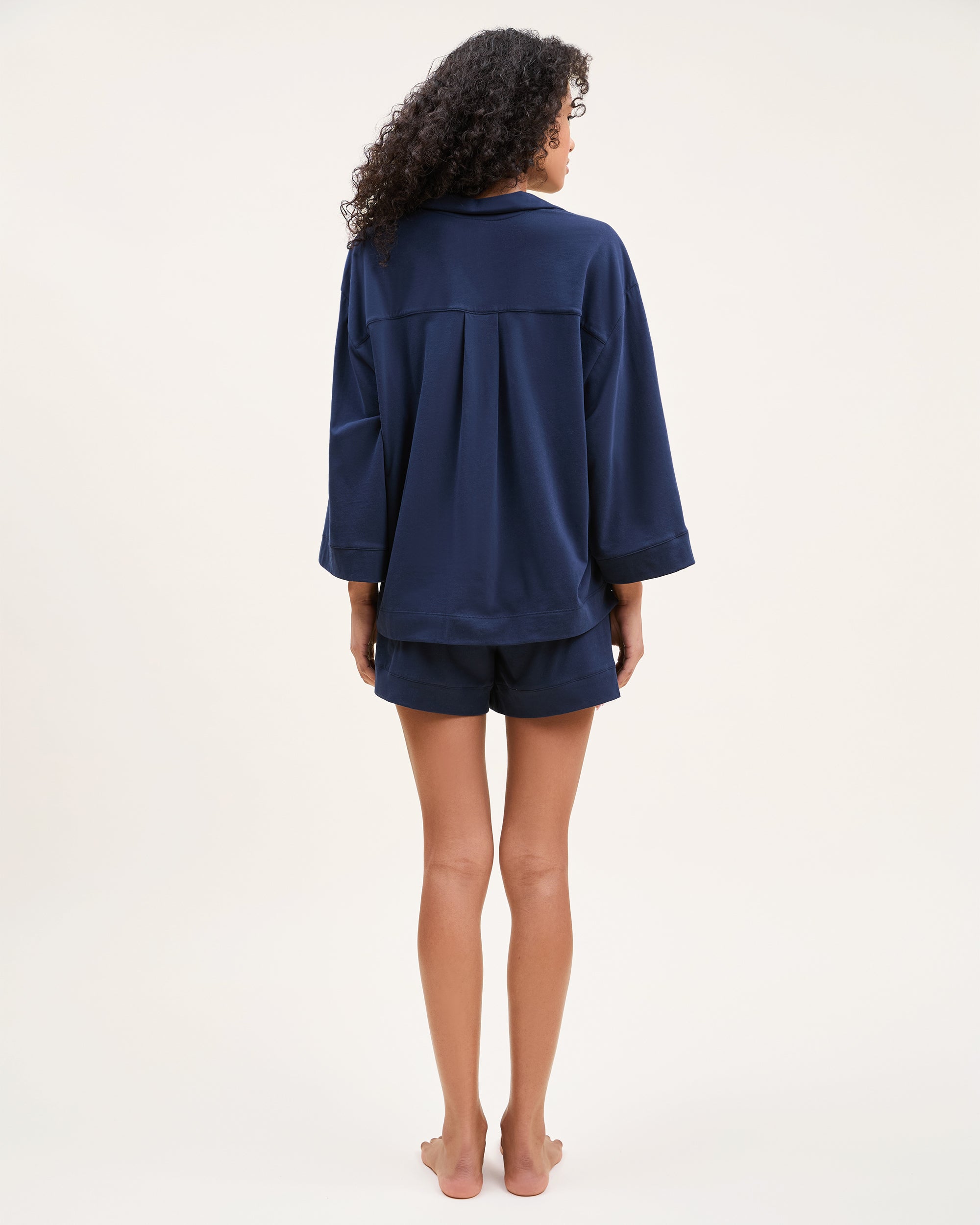 The Olivia Pima Short Set in Navy features a short-sleeve button-up top with a chest pocket and matching drawstring shorts, both displayed flat on a white background.