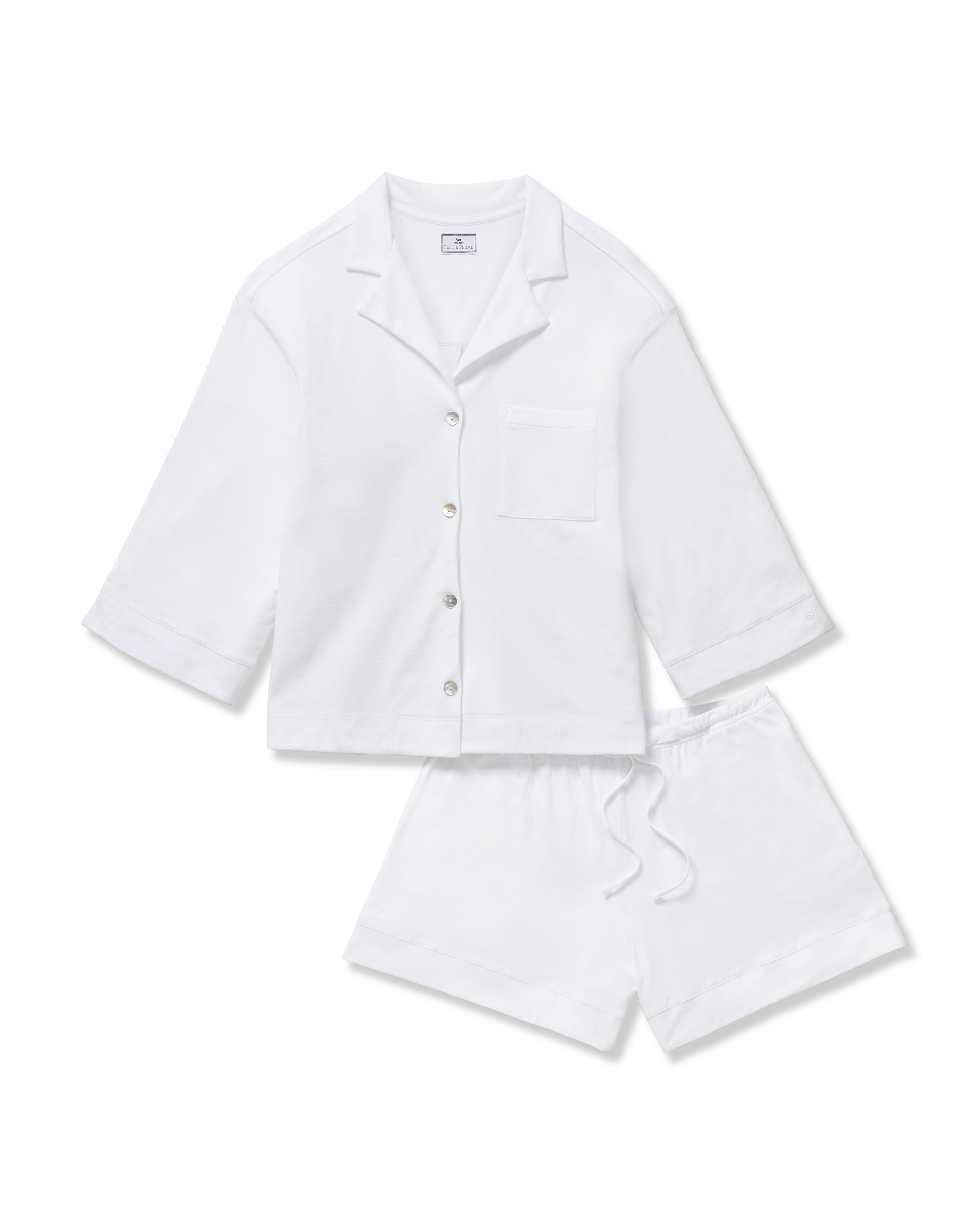 The Olivia Pima Short Set in White features a matching pajama set with a button-up, collared shirt with a chest pocket and three-quarter sleeves, paired with elastic waist drawstring shorts.