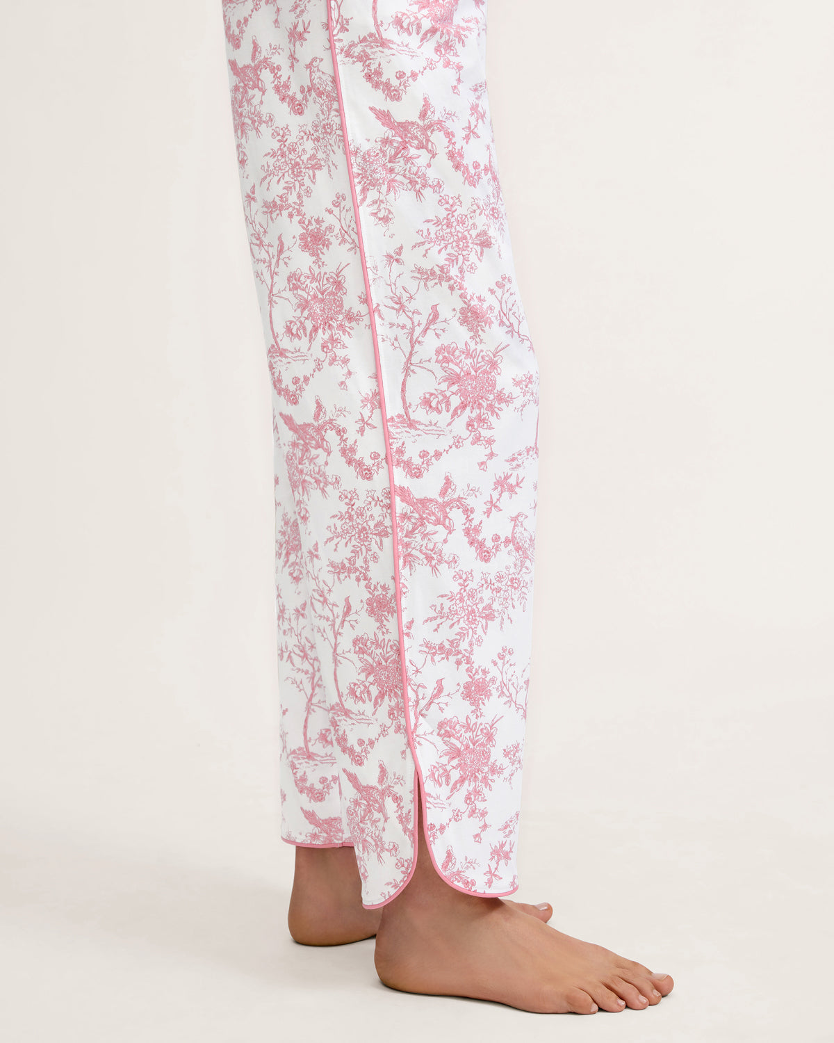 The Margaux Pima Pajama Set in Pink Timeless Toile features long sleeves, soft white fabric with a pink floral toile pattern, and pink piping along the edges and collar.