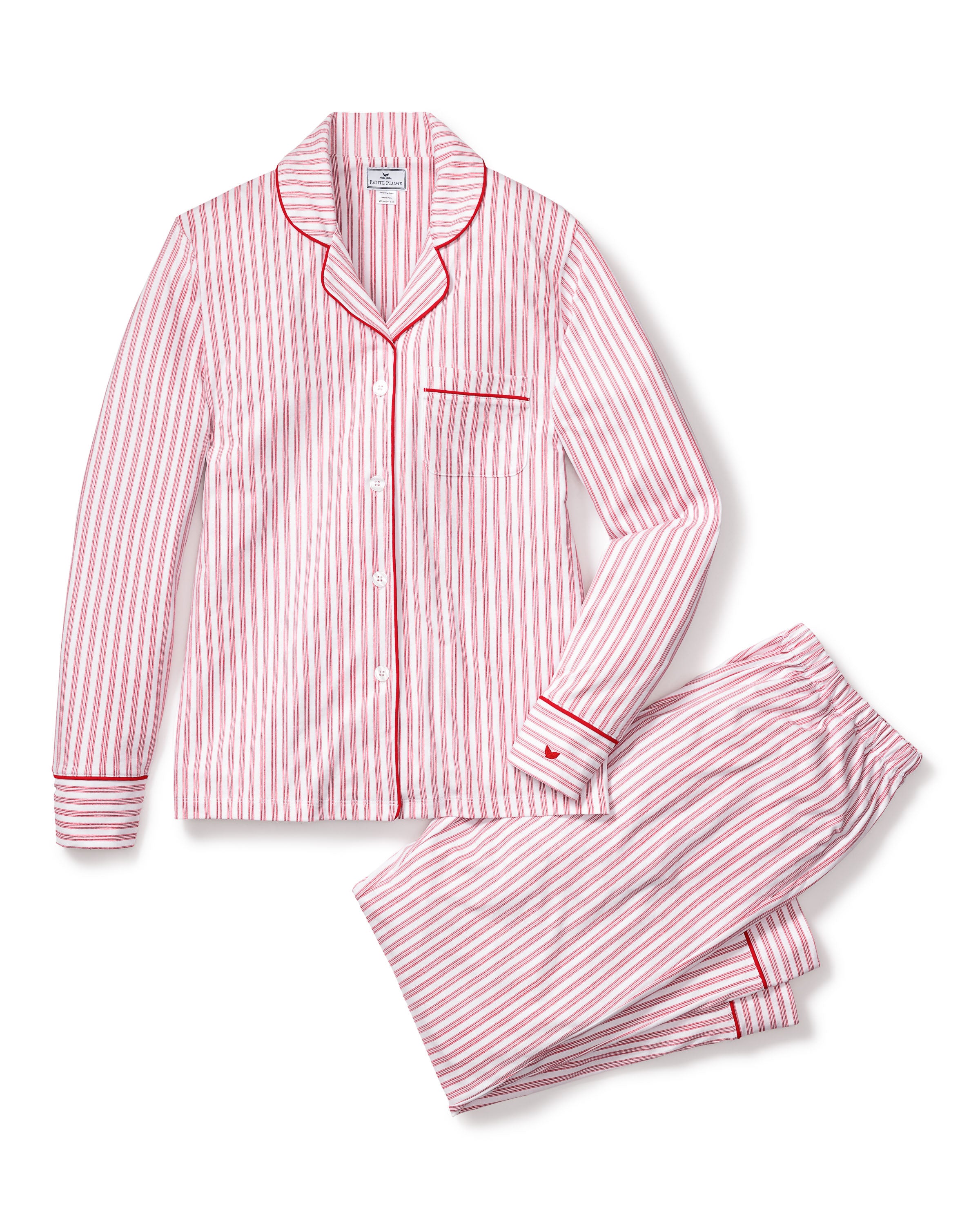 Close-up of Petite Plumes Womens Pima Pajama Set in Antique Red Ticking, showcasing luxury fabric with red and white vertical stripes. The image reveals part of the garment with a white button, collar, and pocket trimmed in red, hinting at its soft and cozy Peruvian Pima cotton.