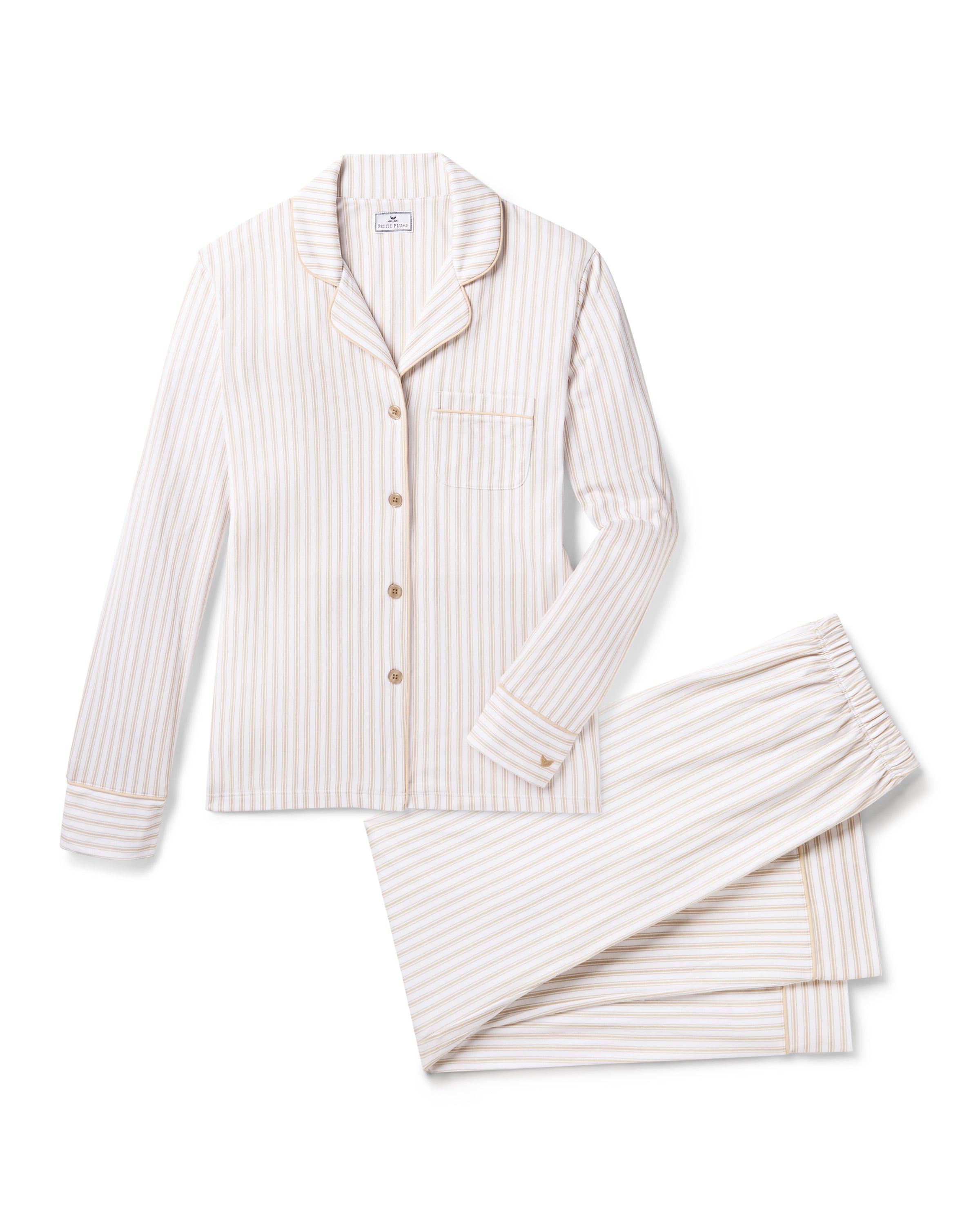 The Women's Pima Pajama Set in Camel Ticking features beige and white vertical stripes, including a long-sleeve button-up top with a chest pocket and matching elastic-waist pants, shown laid flat on a white background.