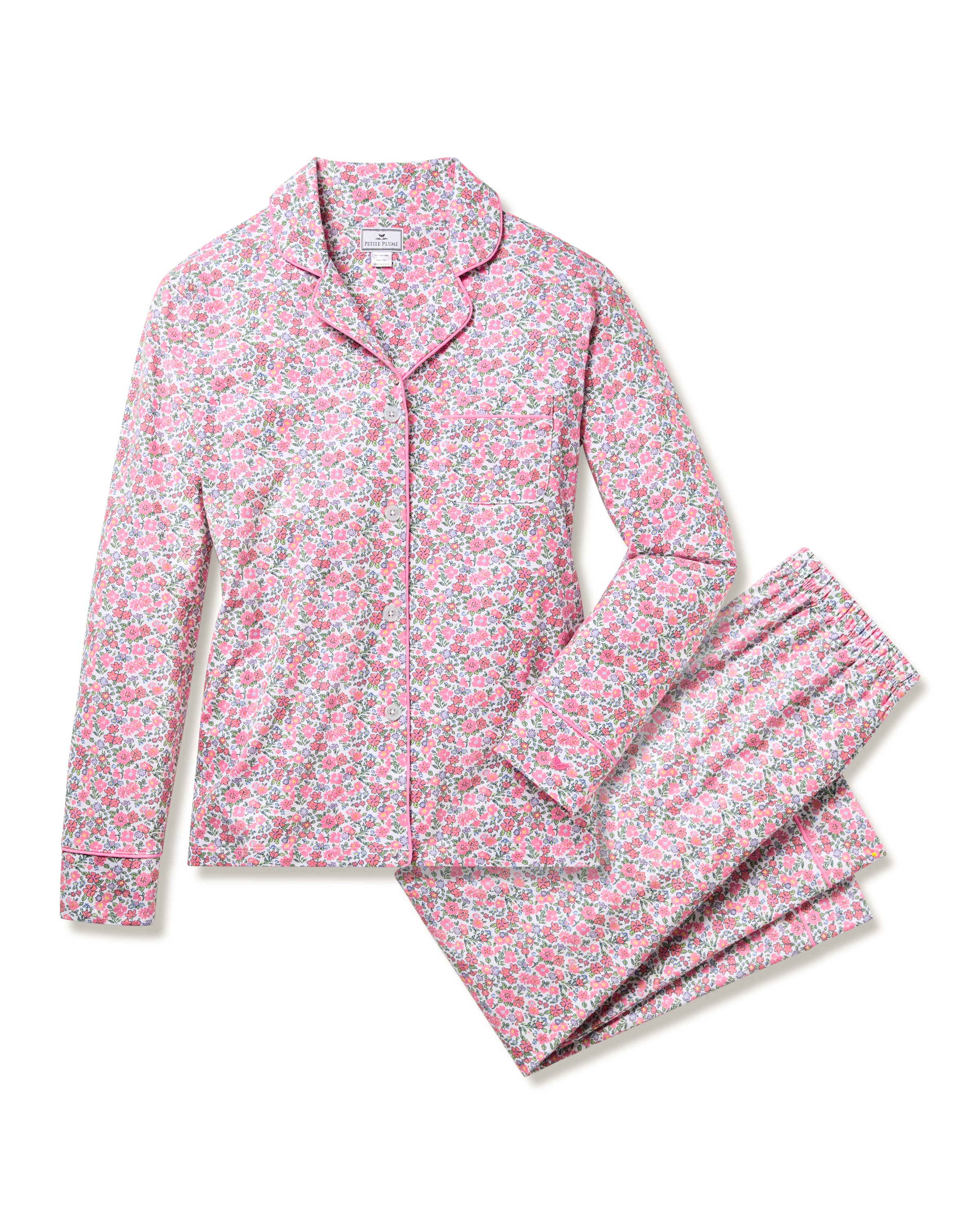 The Womens Pima Pajama Set in Fleurs de Rose by Petite Plume features a long-sleeve button-up top with collar and cuffs and matching pants with an elastic waistband. This floral luxury sleepwear set, in pink, blue, and white, is elegantly displayed on a white background.