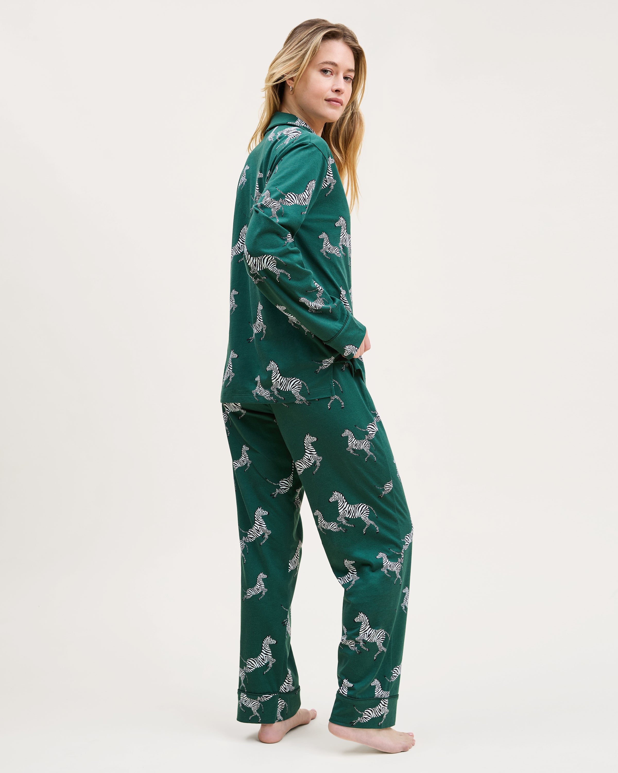 Women's Pima Pajama Set in Zèbre de Forêt: dark green set with button-up long-sleeve shirt and pants, featuring an all-over white zebra print, chest pocket, and collar.