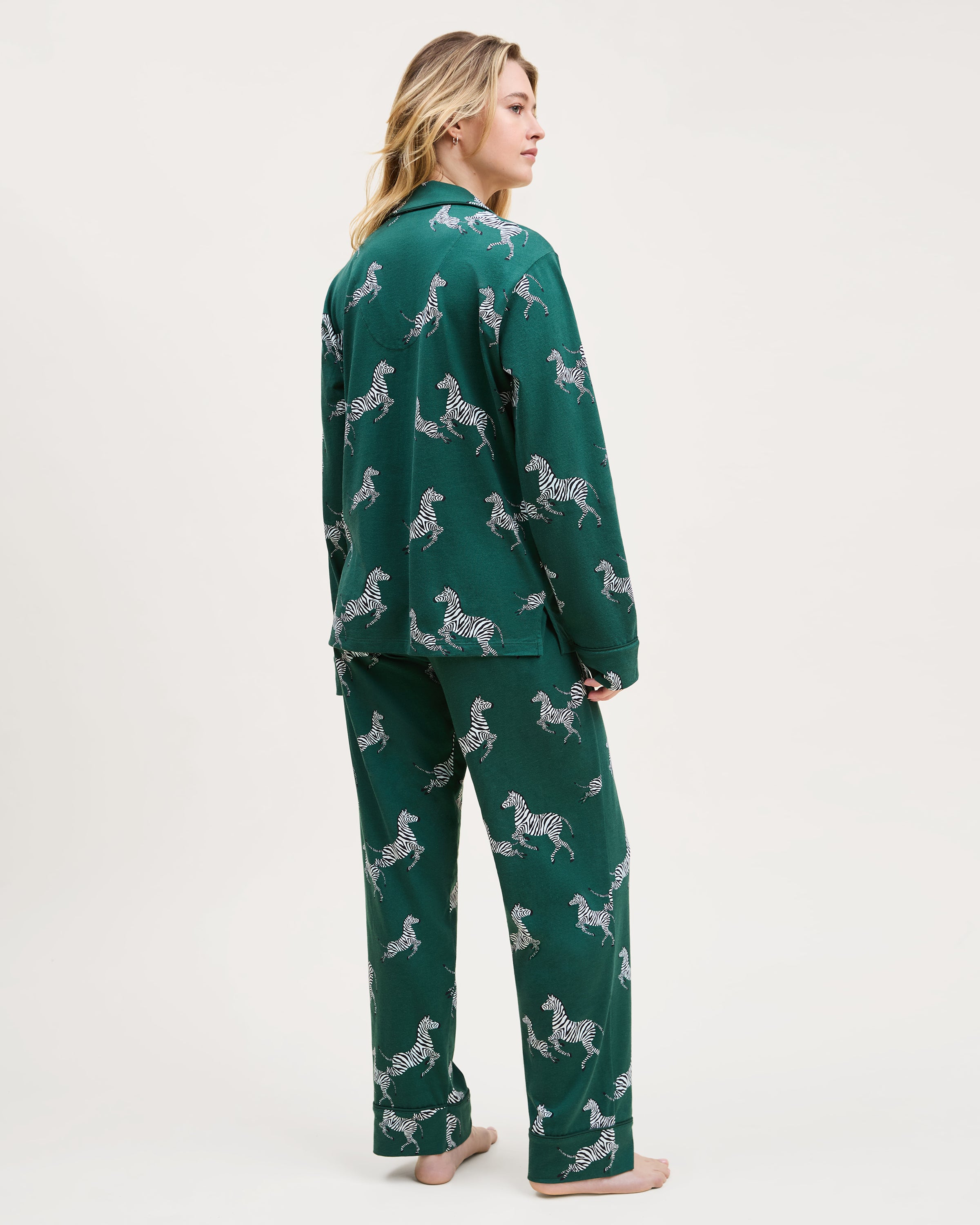 Women's Pima Pajama Set in Zèbre de Forêt: dark green set with button-up long-sleeve shirt and pants, featuring an all-over white zebra print, chest pocket, and collar.