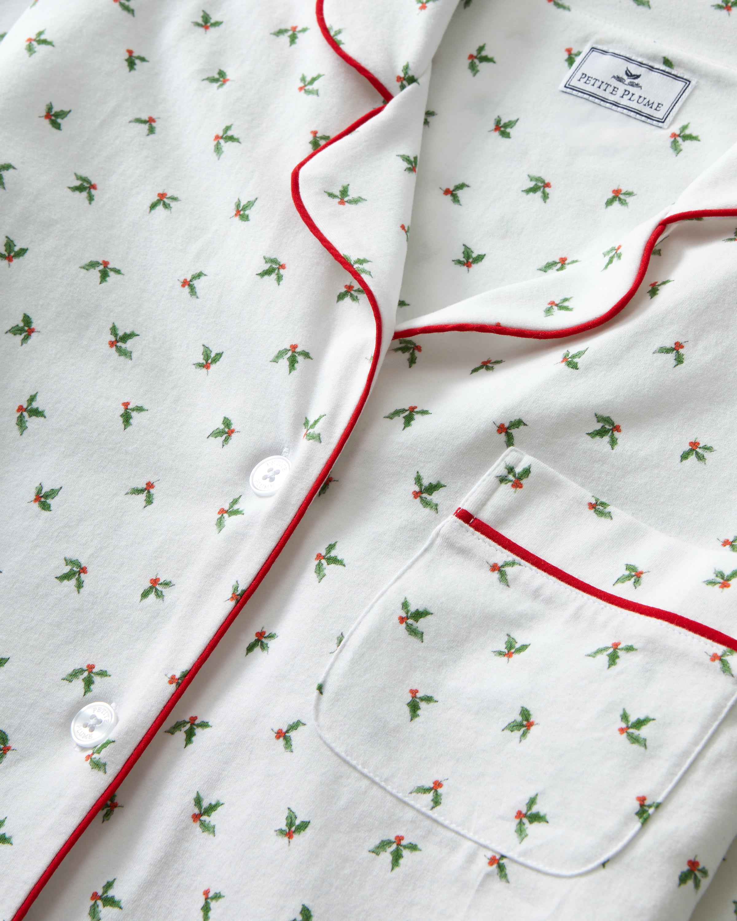 Women's Pima Pajama Set in Mistletoe Moments features small green palm tree prints, red piping, a chest pocket, and matching pants, all displayed flat on a white background.
