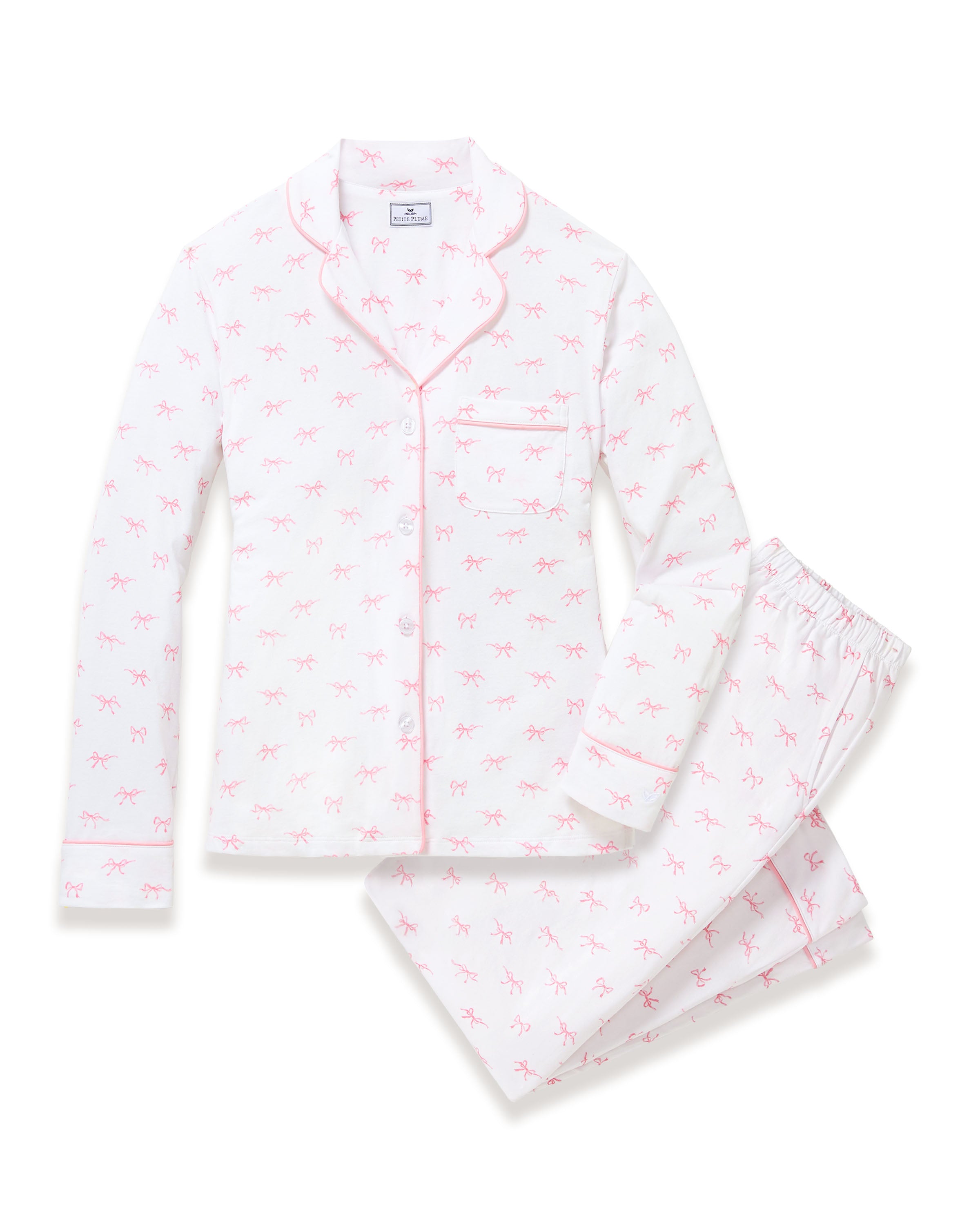 The Women's Pima Pajama Set in Blushing Bows features a long-sleeve button-up top and pants in white fabric with a small pink bow pattern and pink piping accents.