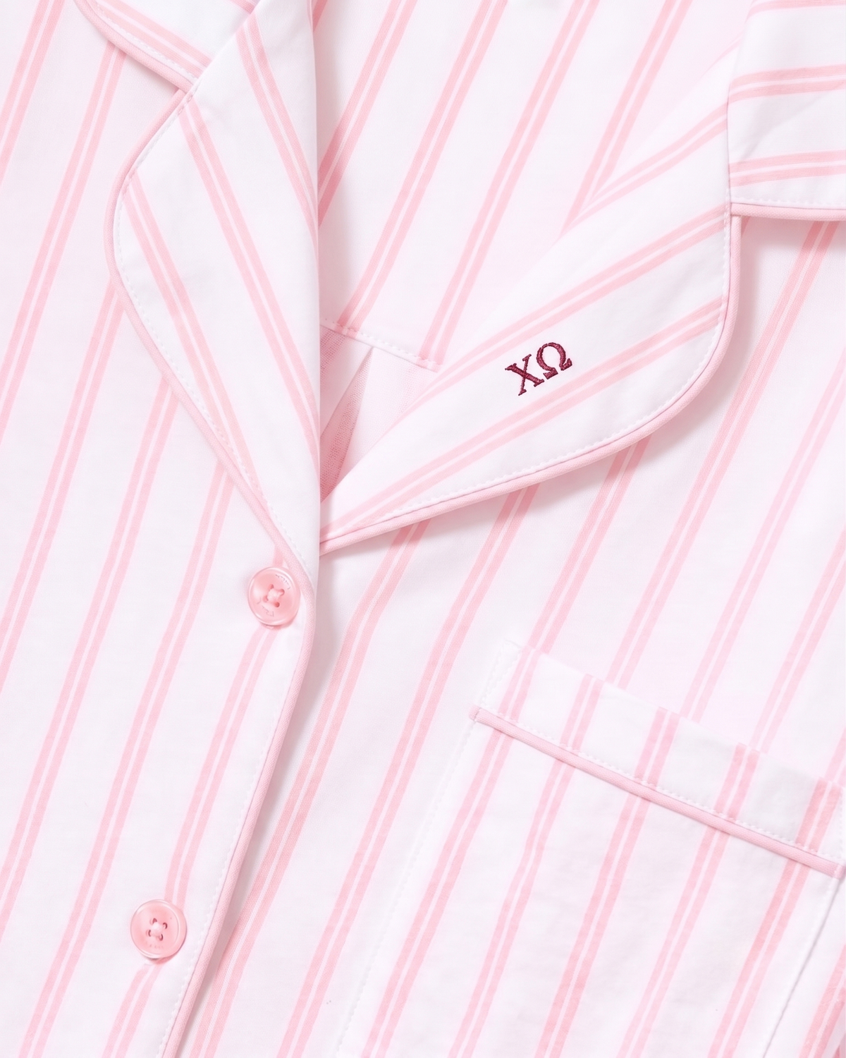 Close-up of the Greek Embroidered Women’s Pima Pajama Set in Pink Stripe, featuring pink buttons, a pocket, and embroidery of the Greek letters ΧΩ above the pocket.