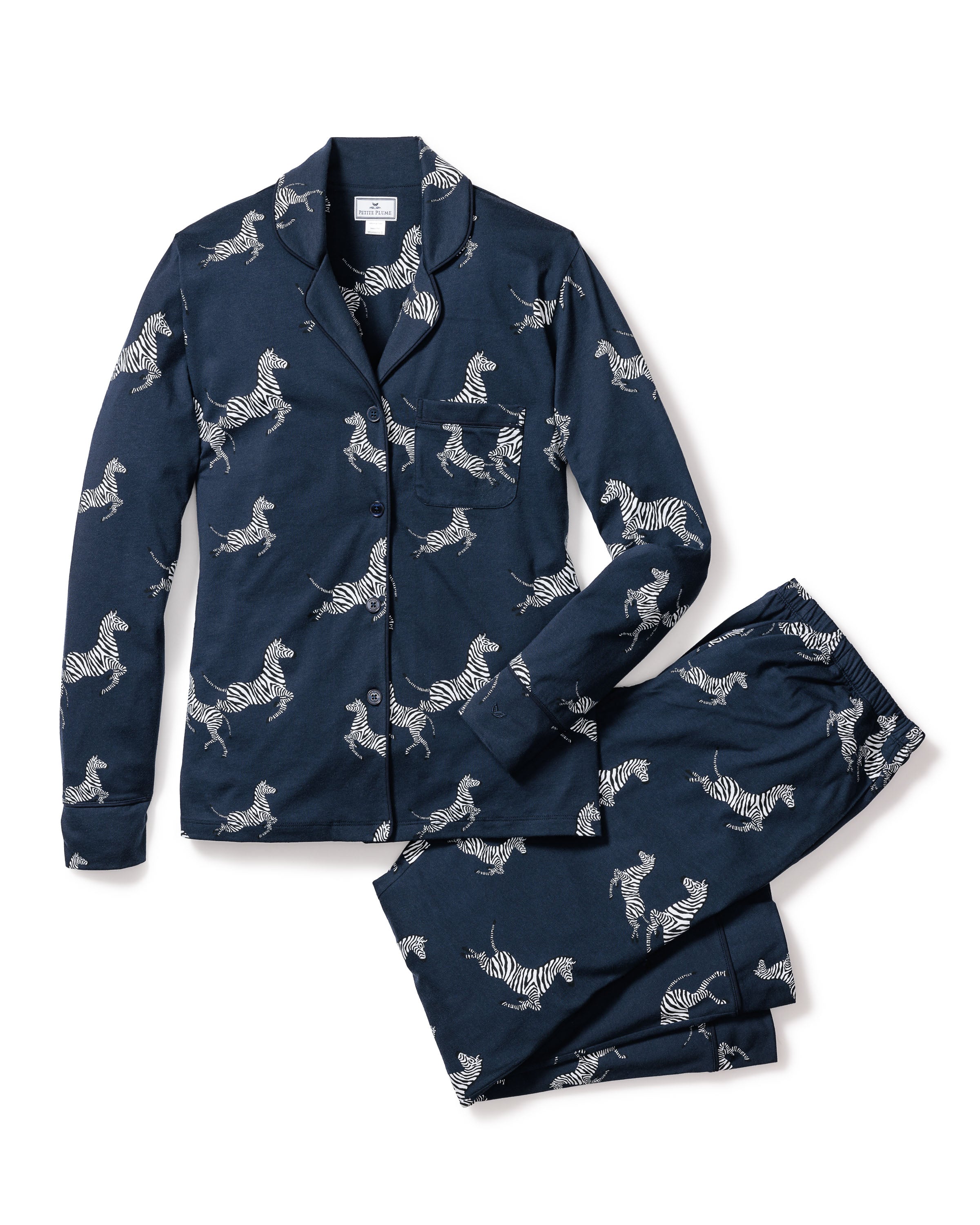 Indulge in luxury sleepwear with Petite Plumes Womens Pima Pajama Set in Zèbre de Nuit, crafted from soft Peruvian Pima cotton. This navy set features a zebra print, including a button-up shirt with a chest pocket and collar, paired with matching trousers for ultimate comfort and style.