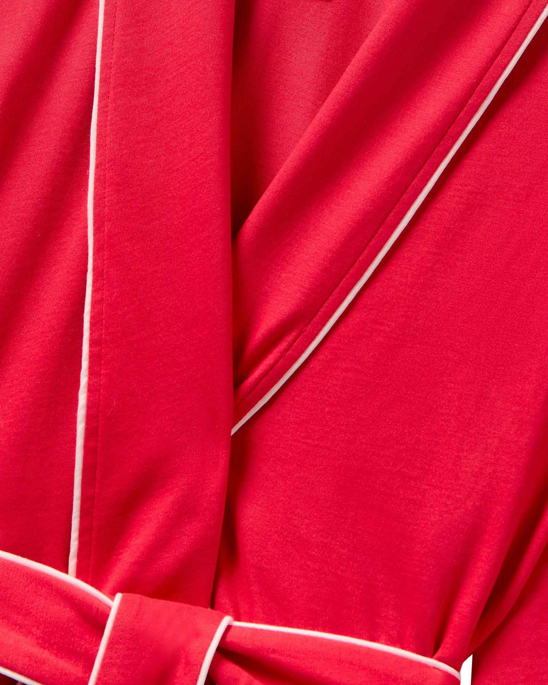 Close-up of Petite Plumes Womens Pima Maternity Robe in Red. The gathered fabric with a knotted belt creates folds, while the red Pima cotton contrasts with subtle white piping, enhancing visual interest.