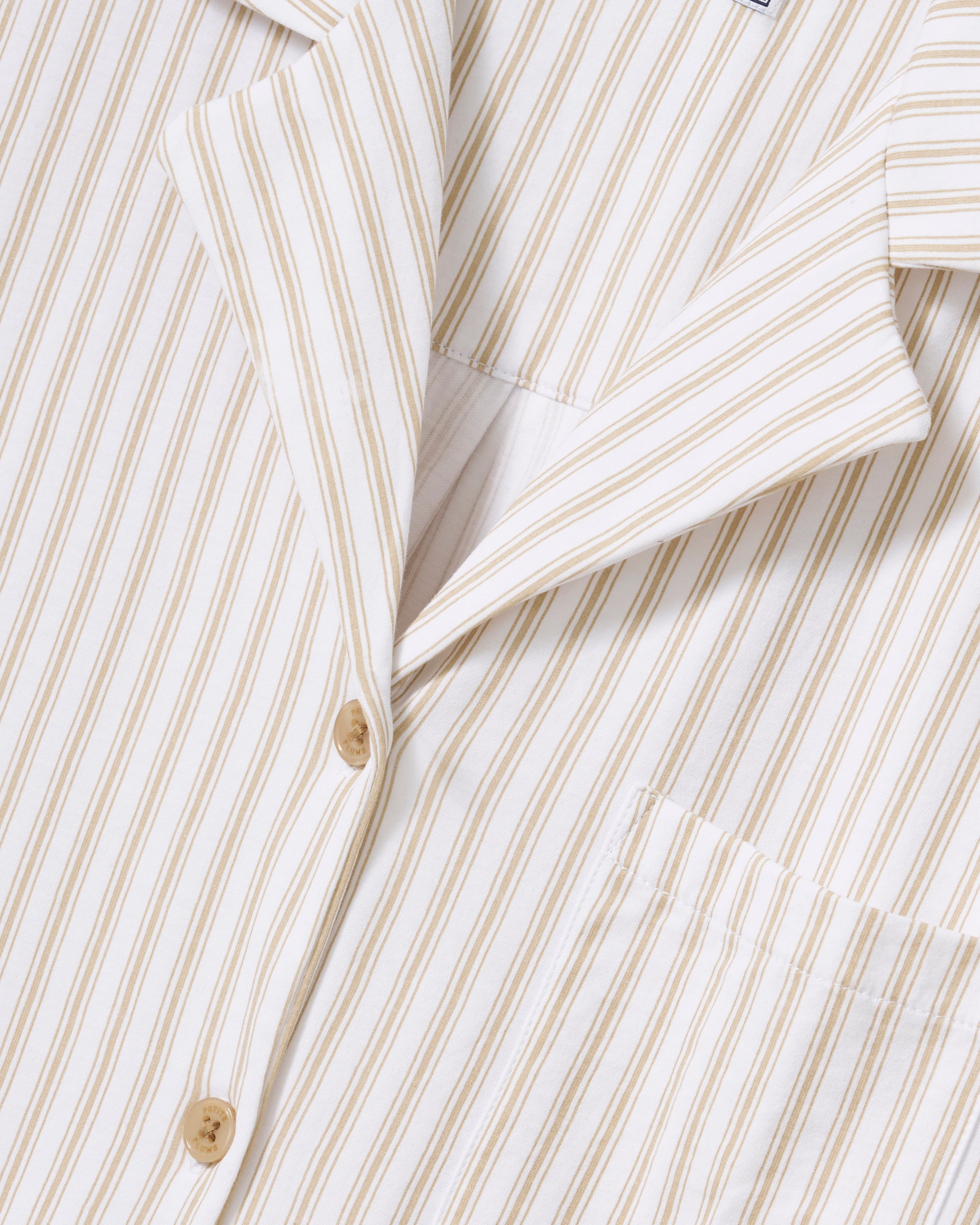 The Olivia Wide Leg Pima Pajama Set in Camel Ticking features light-colored, long-sleeve striped pajamas with brown buttons and matching drawstring pants, displayed flat on a white background.