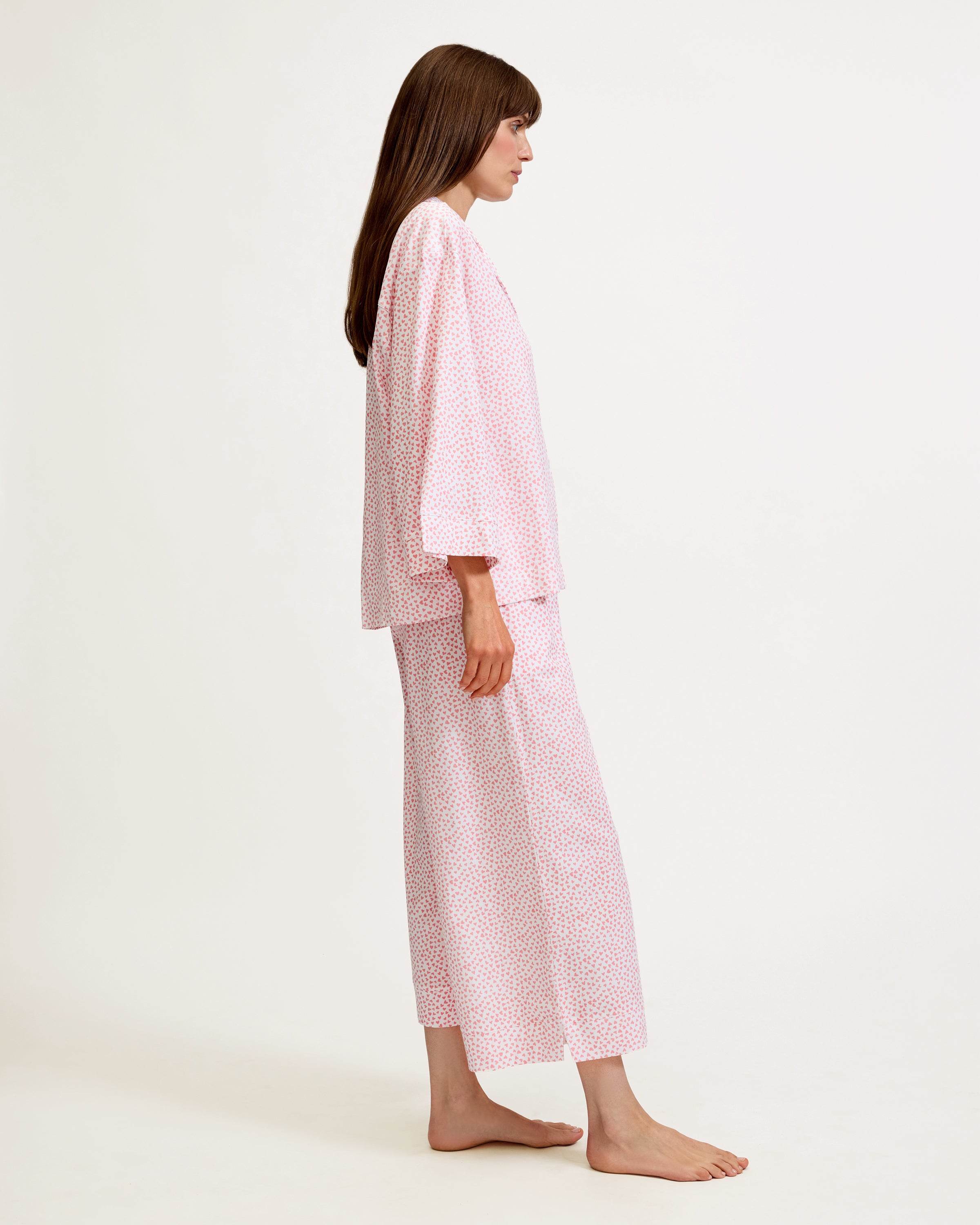 The Olivia Wide Leg Pima Pajama Set in Sweethearts features a light pink and white dotted design, with a collared long-sleeve button-up top and matching wide-leg drawstring pants.