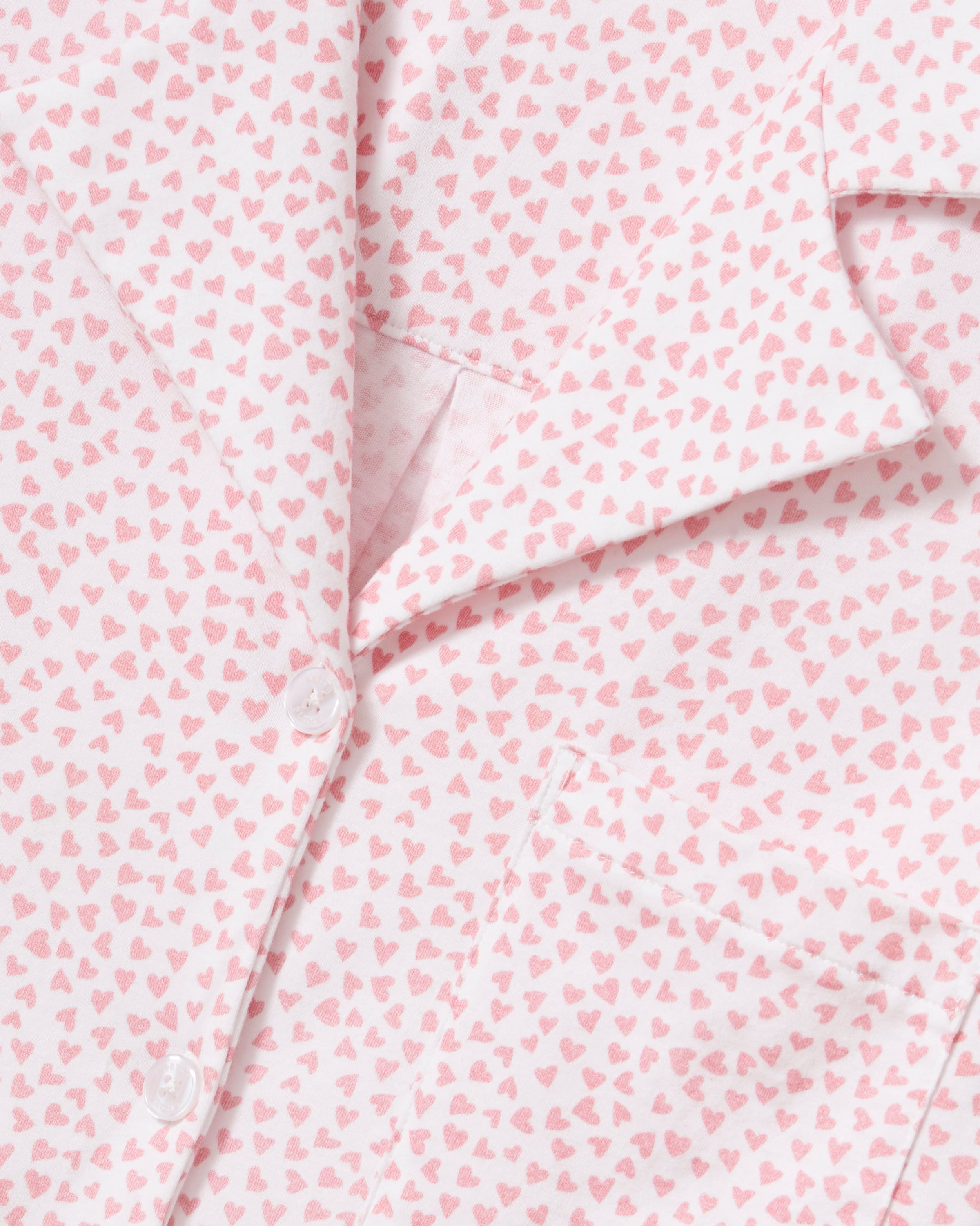 The Olivia Wide Leg Pima Pajama Set in Sweethearts features a light pink and white dotted design, with a collared long-sleeve button-up top and matching wide-leg drawstring pants.
