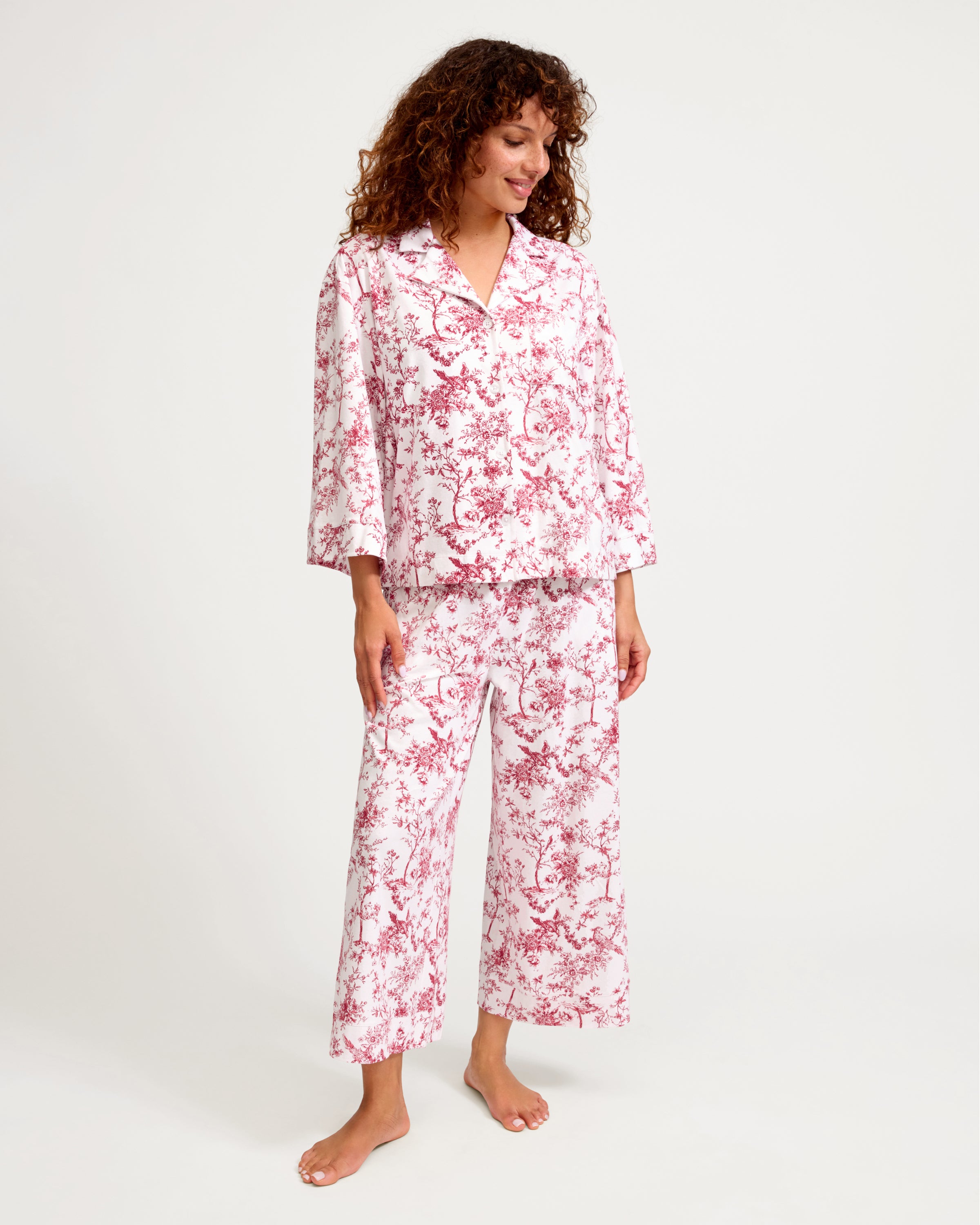 The Olivia Wide Leg Pima Pajama Set in Red Timeless Toile features a long-sleeve button-up shirt and pants with a white background and a red floral and tree branch design.
