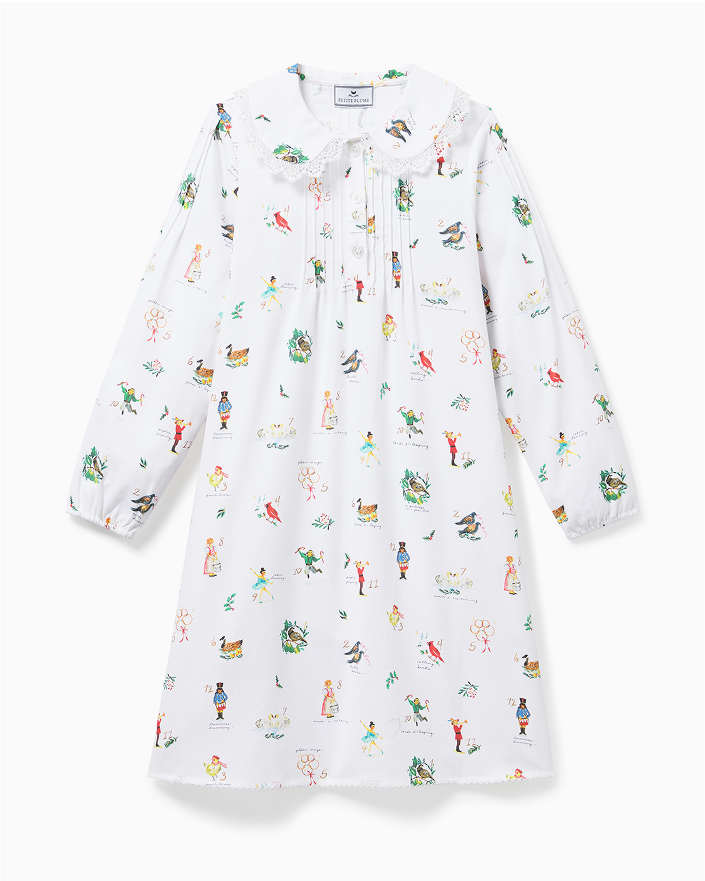 A long-sleeved white dress with a rounded collar, decorated with colorful, whimsical illustrations of animals, people, and holiday-themed motifs, displayed against a plain white background.