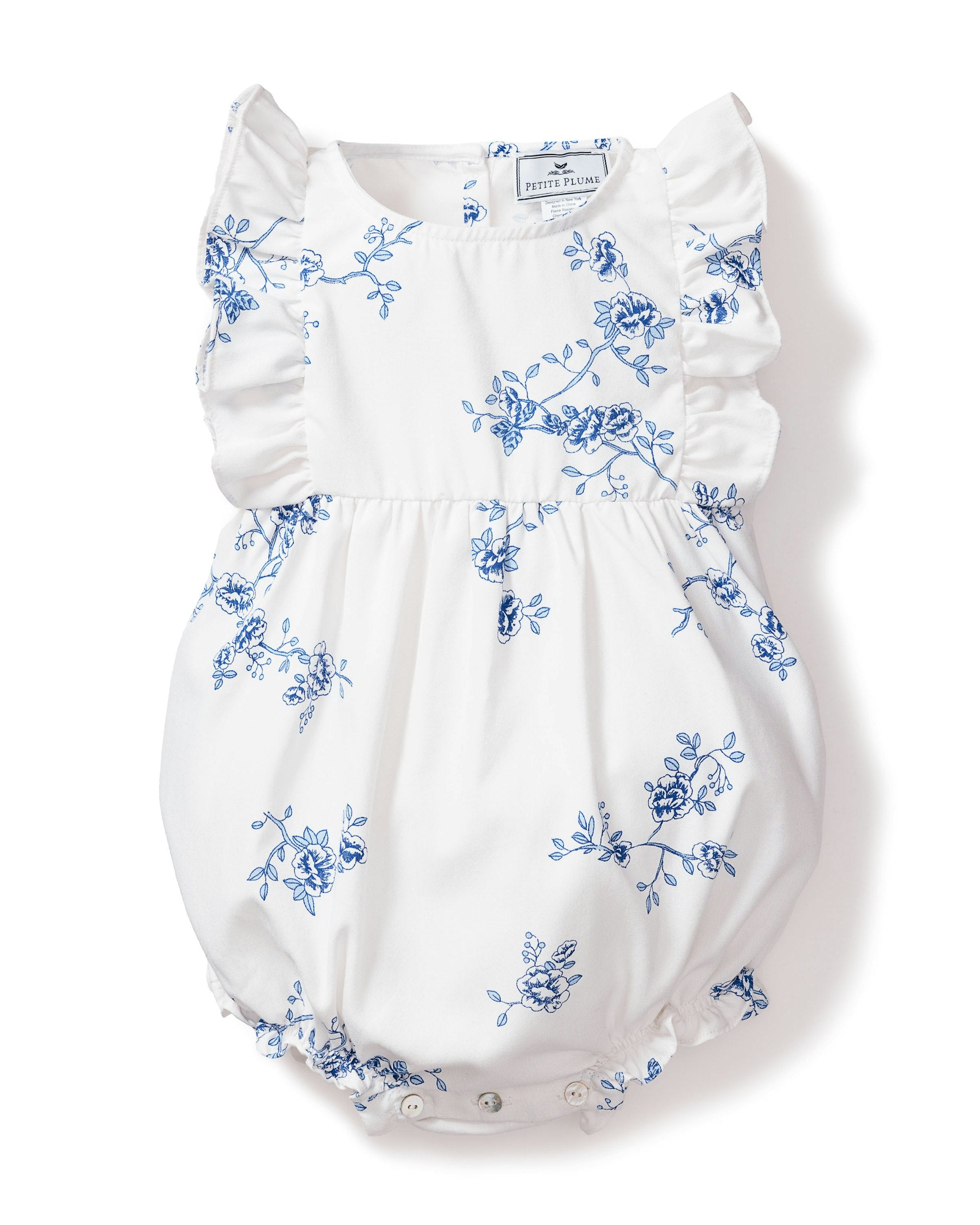 A white baby romper with blue floral print, ruffled hems and sleeves, and pearl buttons.
