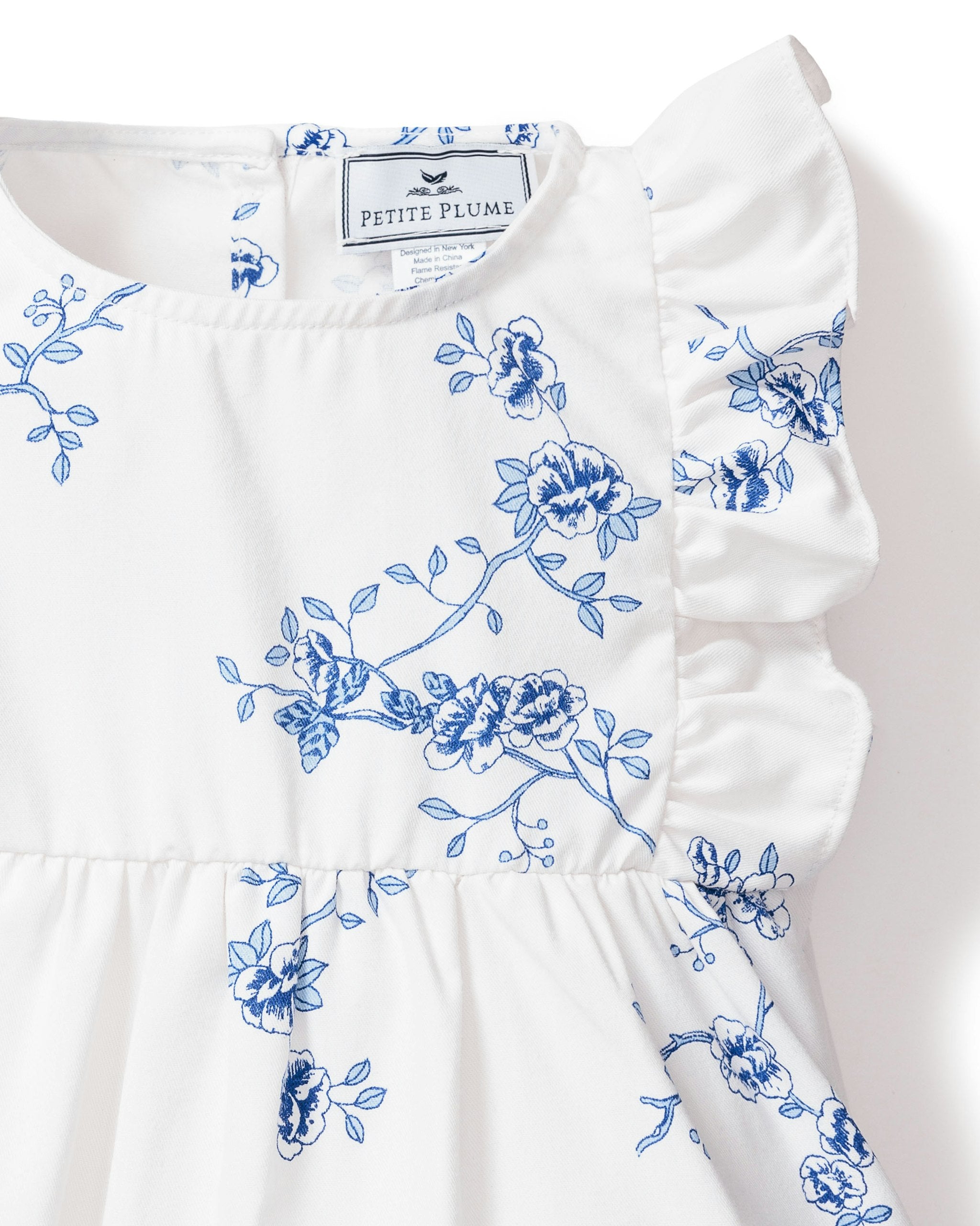 White dress with blue floral patterns on a plain background