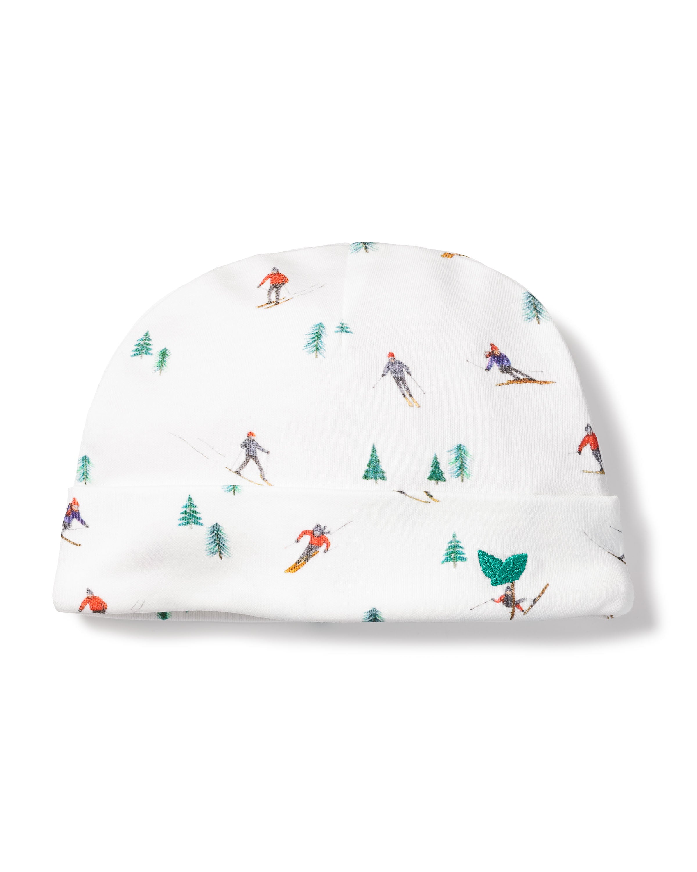 The Babys Pima Hat in Après Ski by Petite Plume, made from soft Peruvian Pima cotton, features a playful skier and green tree design. It keeps your little ones head warm while being gentle on delicate skin and adds a cheerful winter-themed touch.