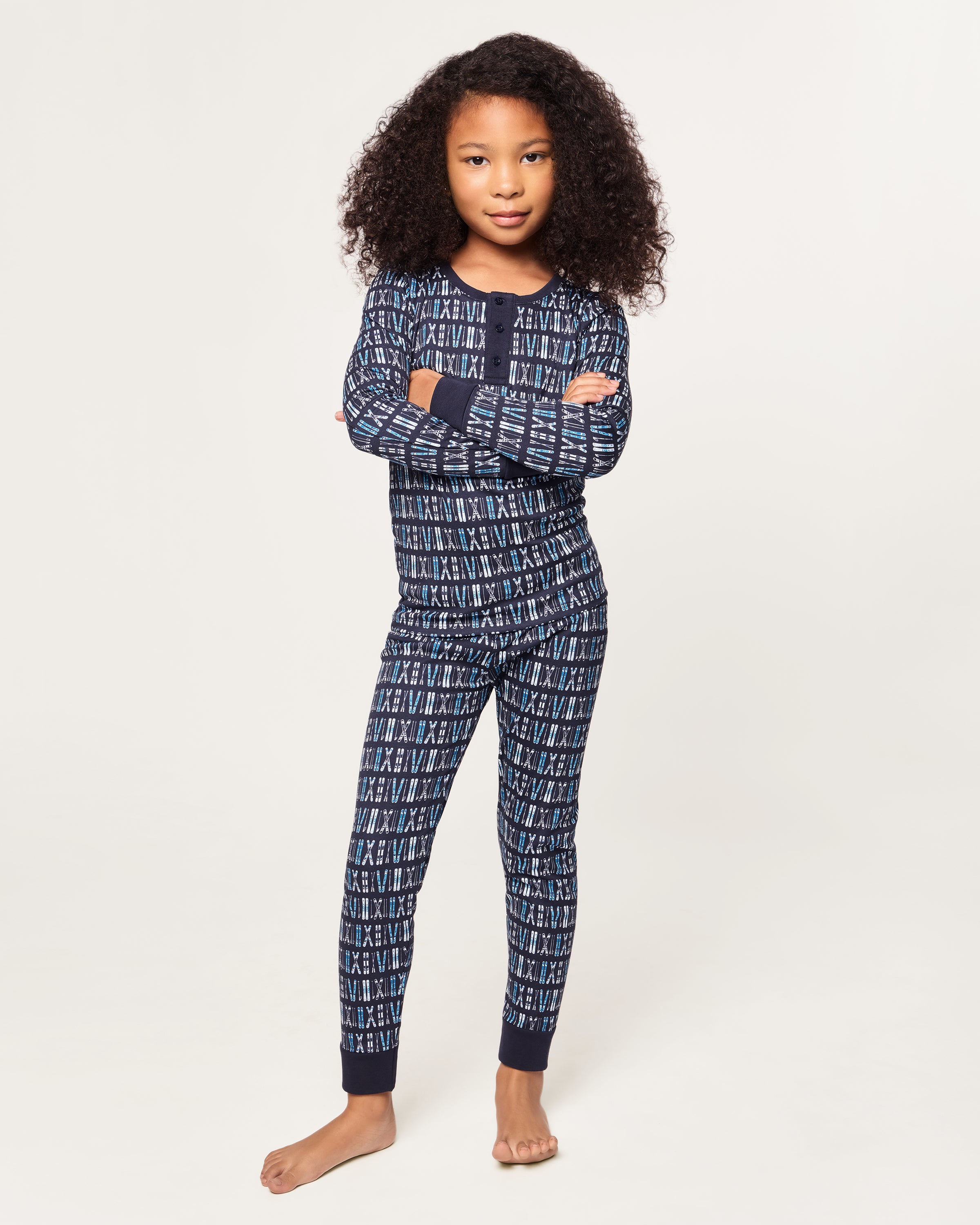 The Kid's Pima Snug Fit Pajama Set in Ski Trails features a coordinated long-sleeve top and pants with a blue and black geometric design and dark blue cuffs on the sleeves, neckline, and pant legs.