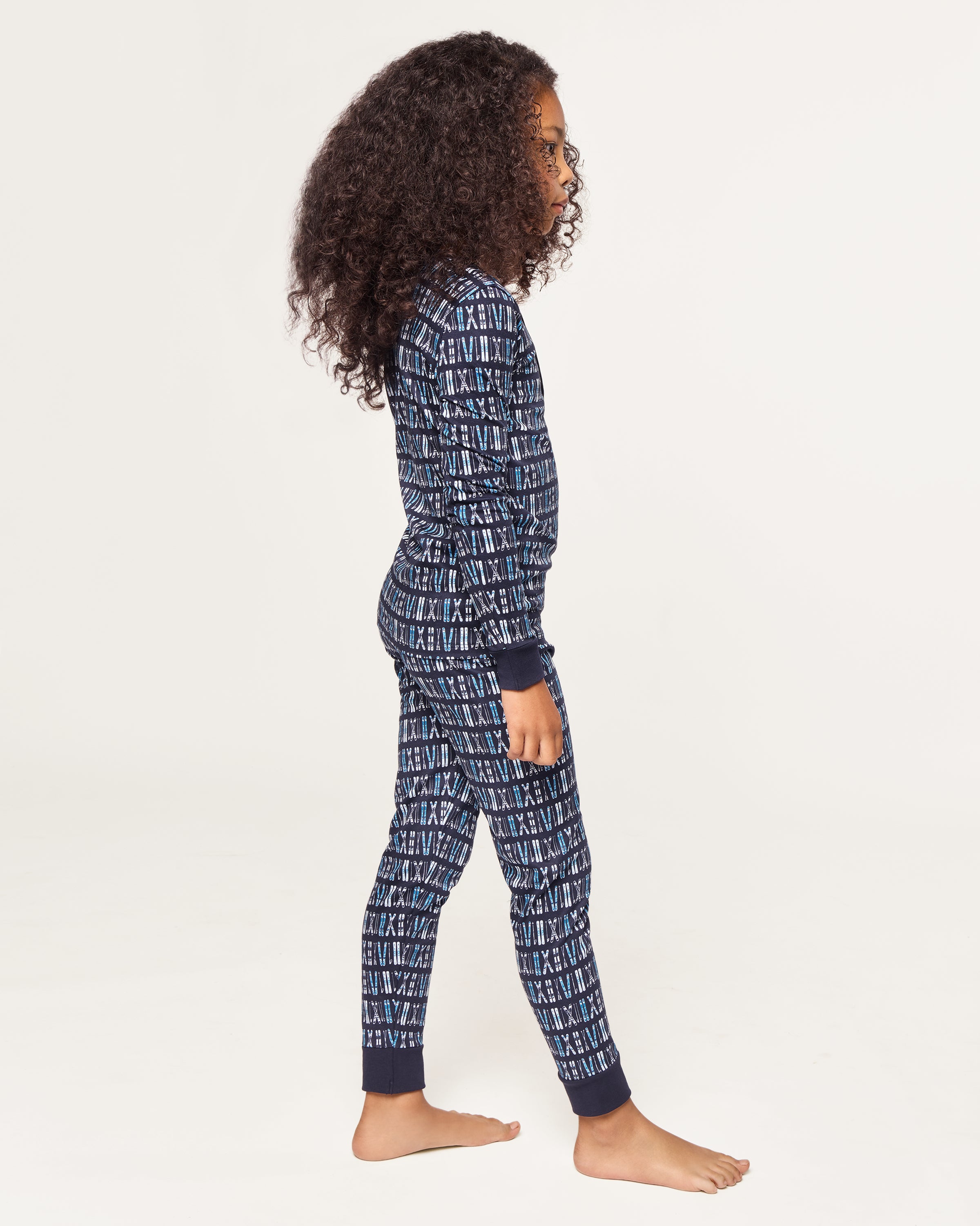 The Kid's Pima Snug Fit Pajama Set in Ski Trails features a coordinated long-sleeve top and pants with a blue and black geometric design and dark blue cuffs on the sleeves, neckline, and pant legs.