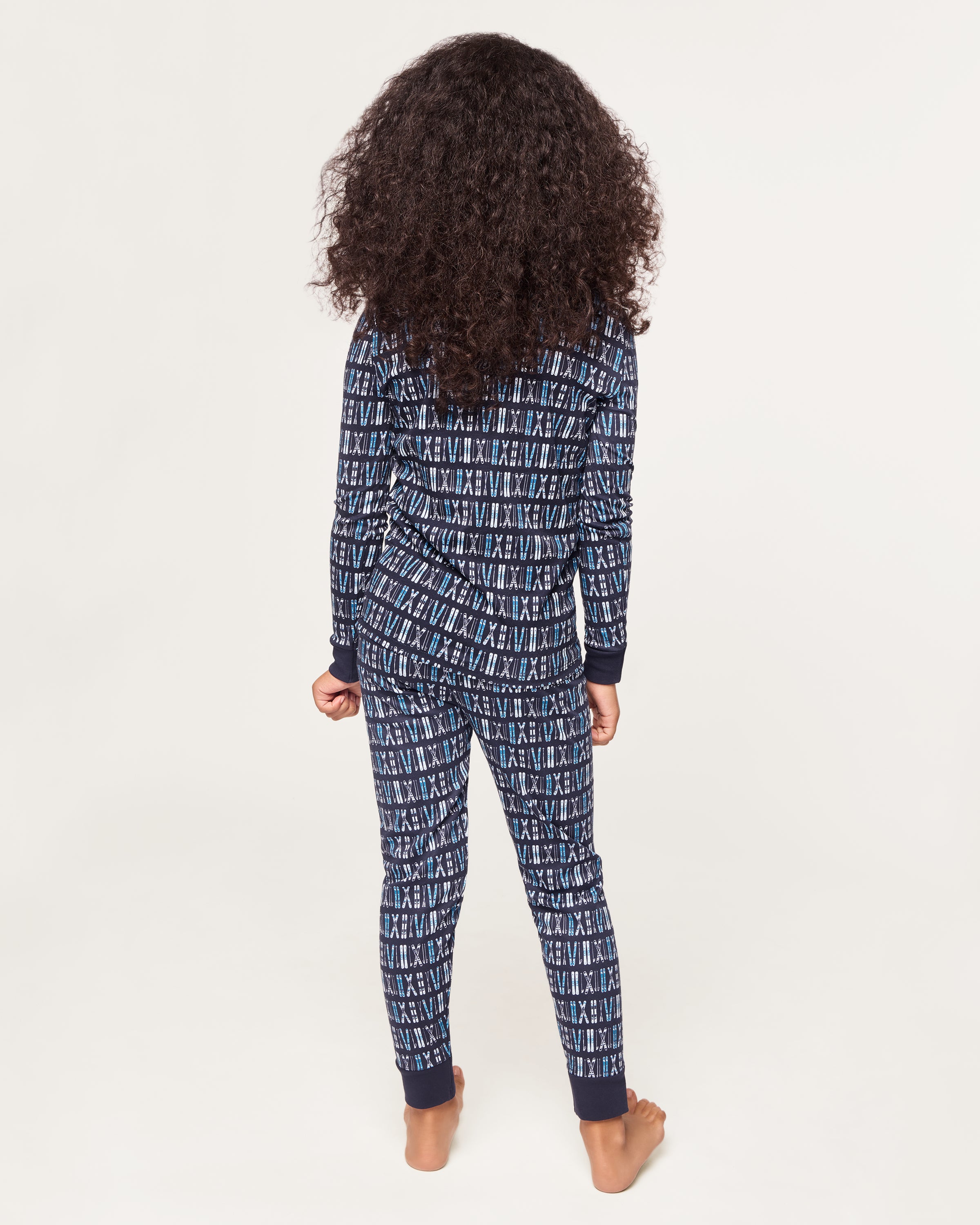 The Kid's Pima Snug Fit Pajama Set in Ski Trails features a coordinated long-sleeve top and pants with a blue and black geometric design and dark blue cuffs on the sleeves, neckline, and pant legs.