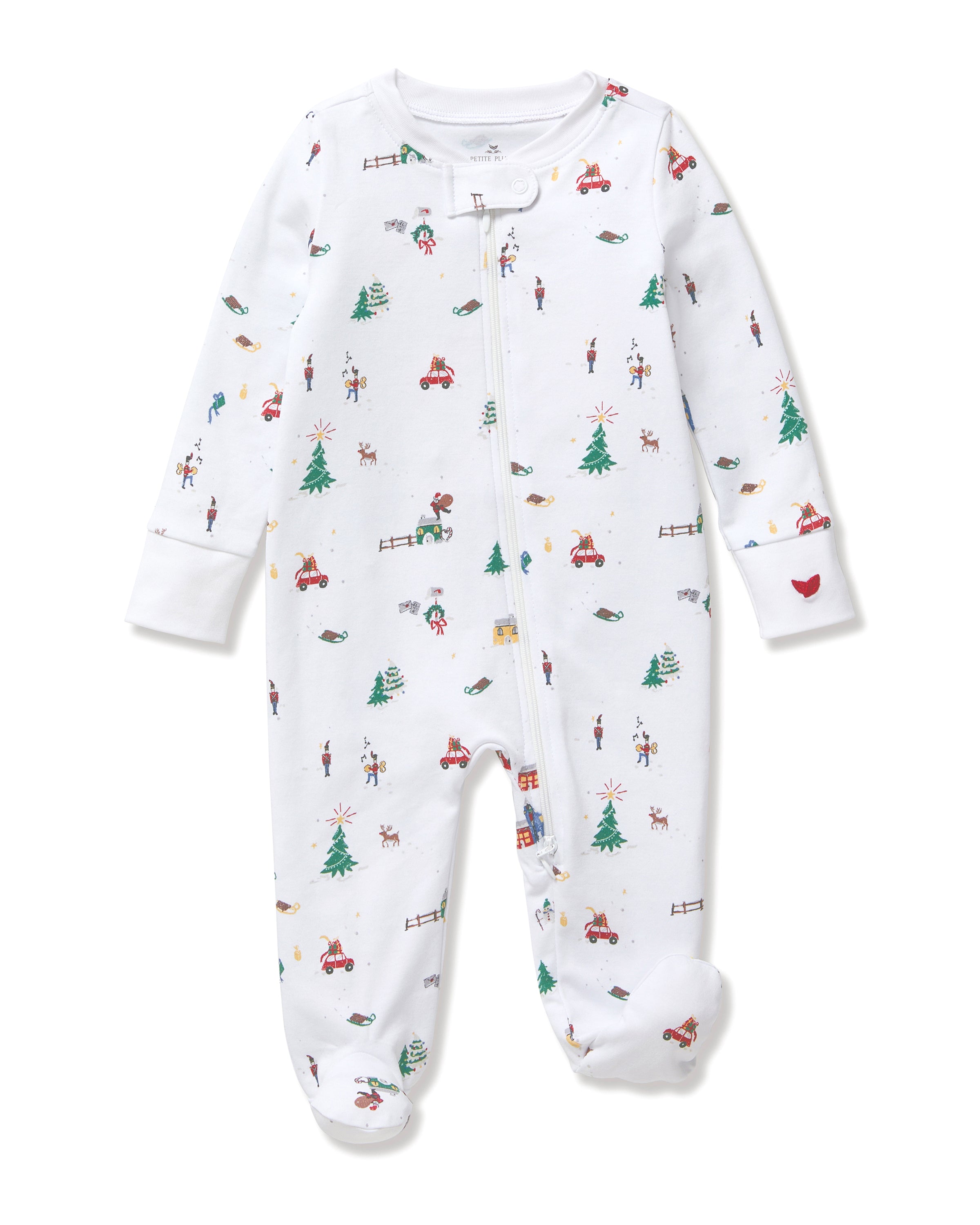 The Baby's Pima Romper in Holiday Town is a white footed sleeper with a diagonal zipper, featuring colorful prints of Christmas trees, reindeer, cars, snowmen, fences, and hearts.