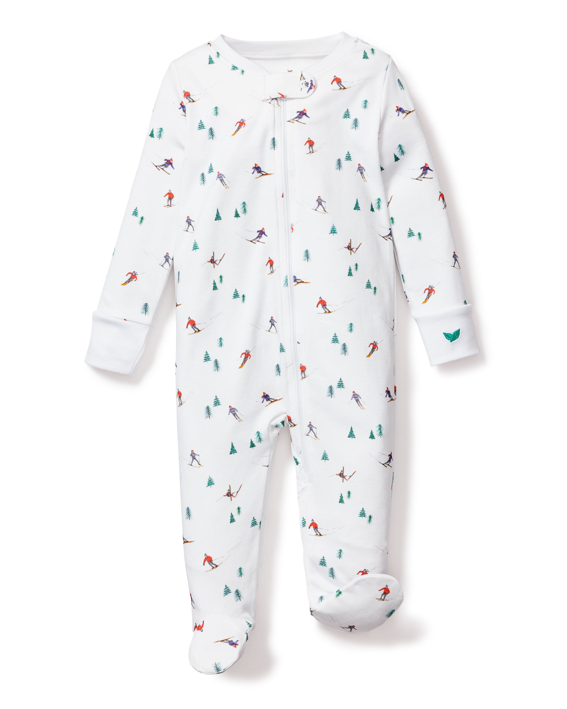 The Petite Plume Babys Pima Romper in Après Ski is a white onesie crafted from soft Pima cotton, featuring a zip-up front, long sleeves, enclosed feet, and charming skier and evergreen tree patterns in green, blue, red, and purple for extra warmth.