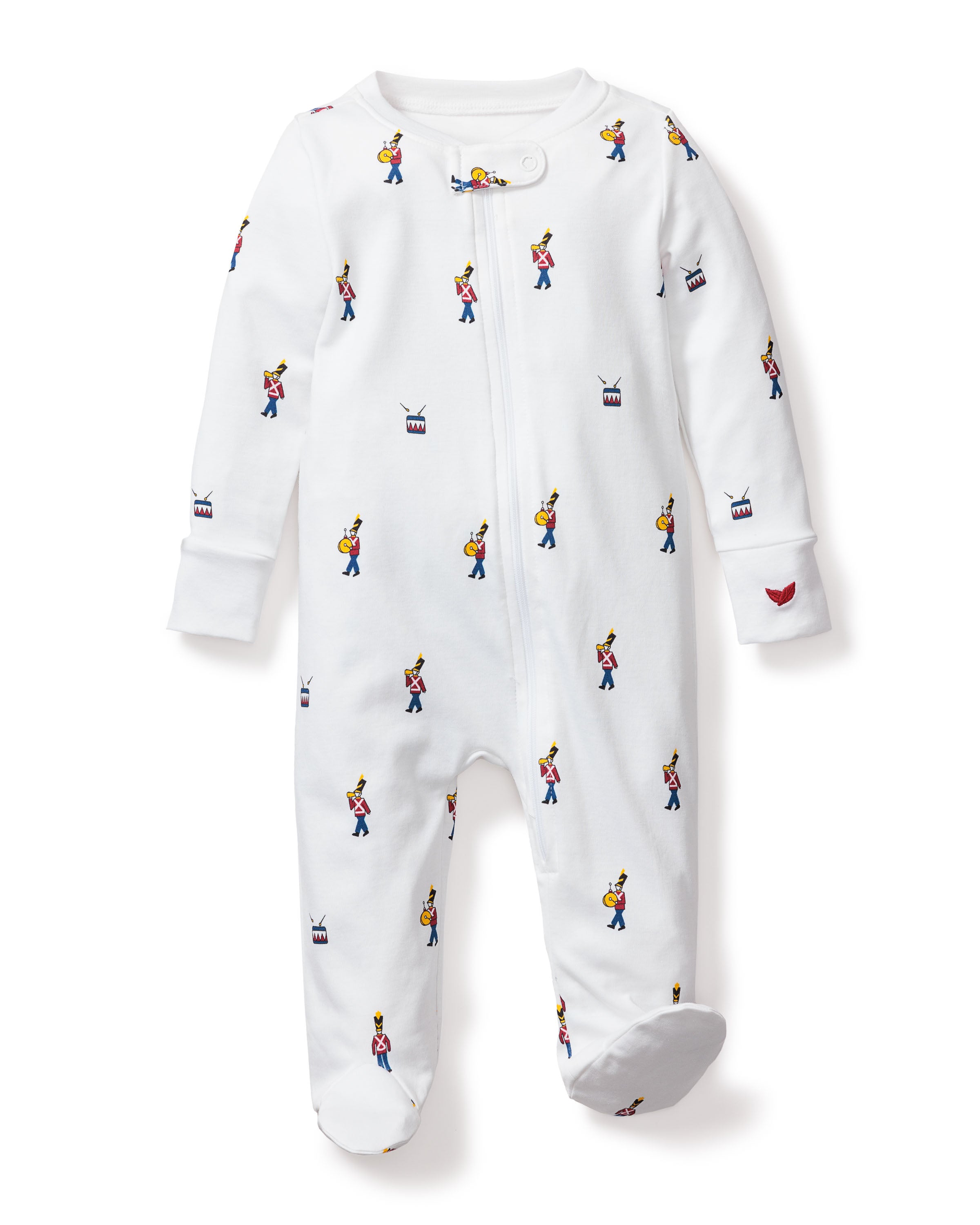 The Petite Plume Babys Pima Romper in Toy Soldier is a white, cozy infant romper featuring a colorful marching band pattern, made from soft Pima cotton. It includes a convenient front zipper and has a charming small red heart on one sleeve. Ideal for baby sleepwear.