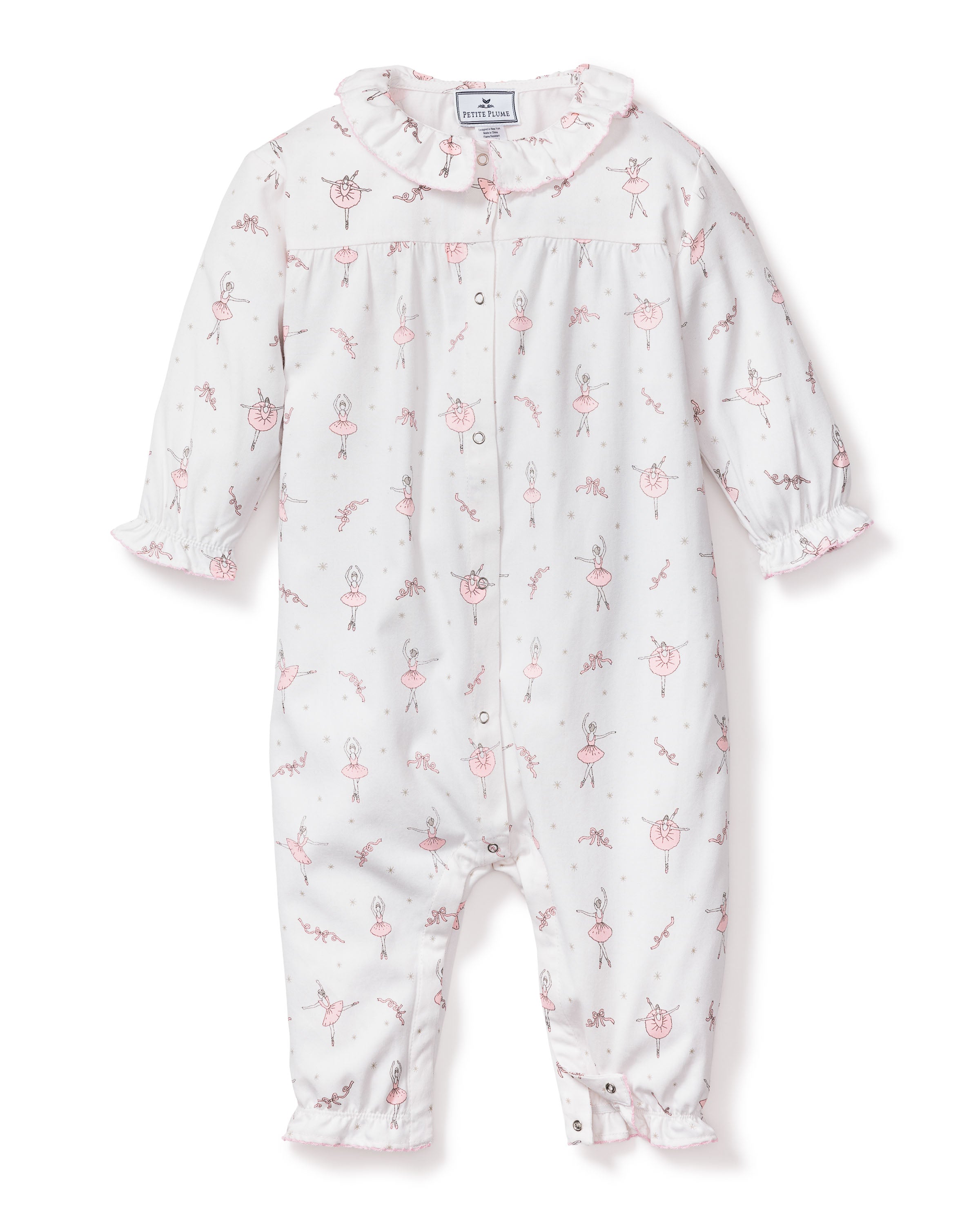 The Petite Plume Babys Flannel Madeline Romper in Sugar Plum Fairy features a white onesie with pink ballerina and bunny prints made of flame-retardant fabric. It includes a ruffled collar and cuffs, snap closures down the front and legs, making it perfect for childrens sleepwear.