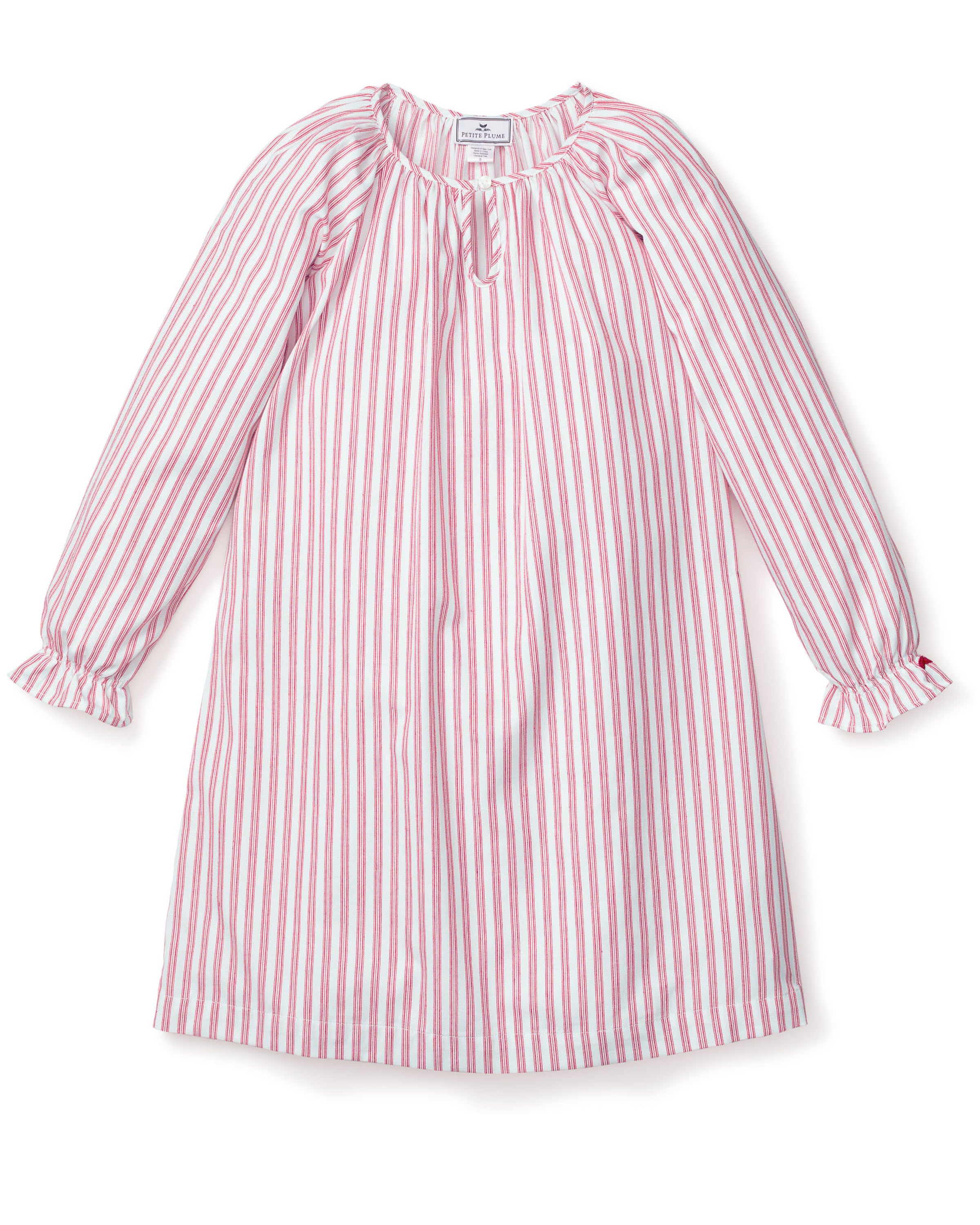 Close-up of Petite Plumes Girls Twill Delphine Nightgown in Antique Red Ticking, featuring pink and white stripes with red stitched ruffles and an embroidered star. Ideal for childrens sleepwear, its smooth texture highlights the detailed pattern and craftsmanship.