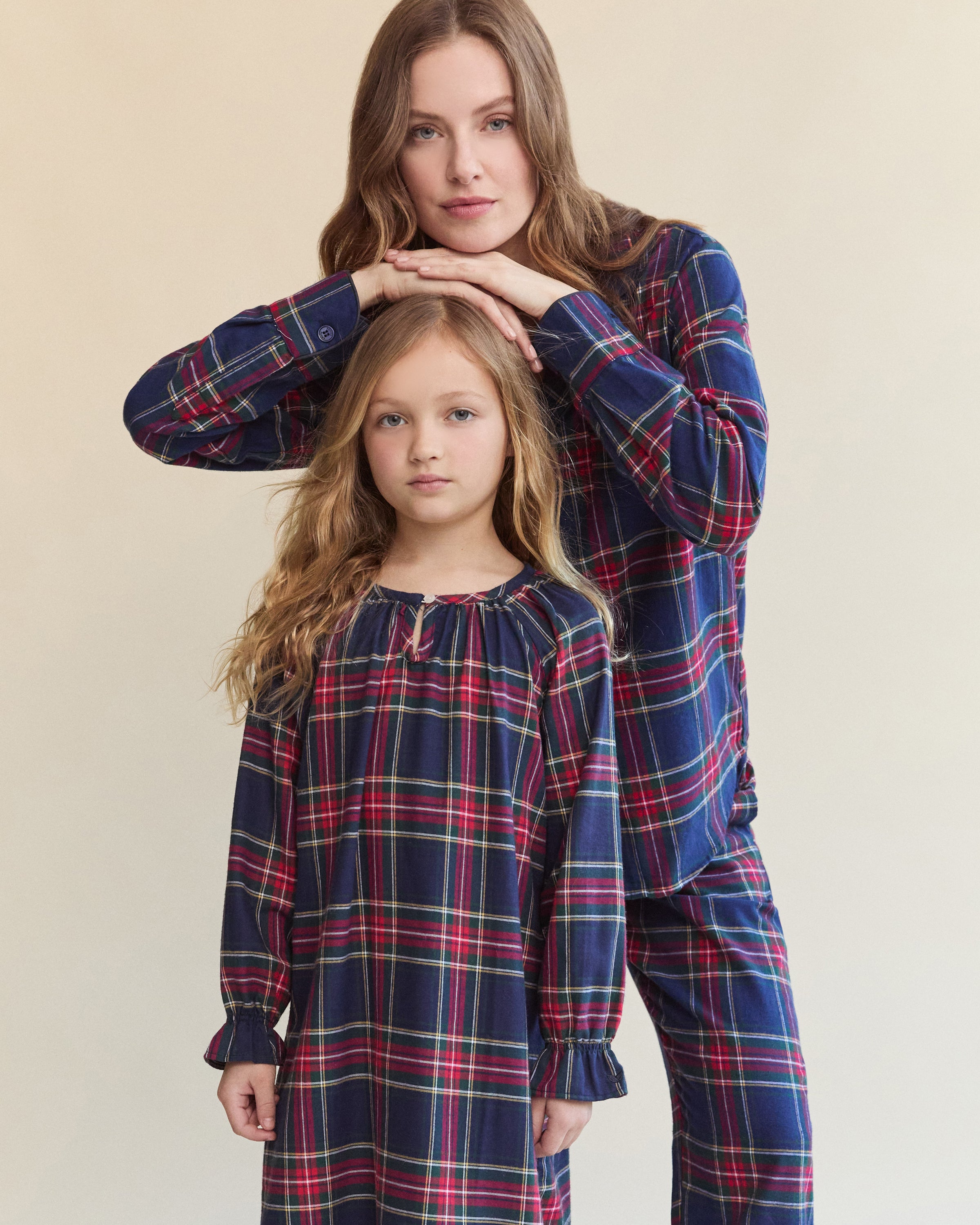The Girl's Brushed Twill Delphine Nightgown in Windsor Tartan features a blue, green, and red plaid pattern, knee-length long sleeves with ruffled cuffs, and a round neckline with a small button.
