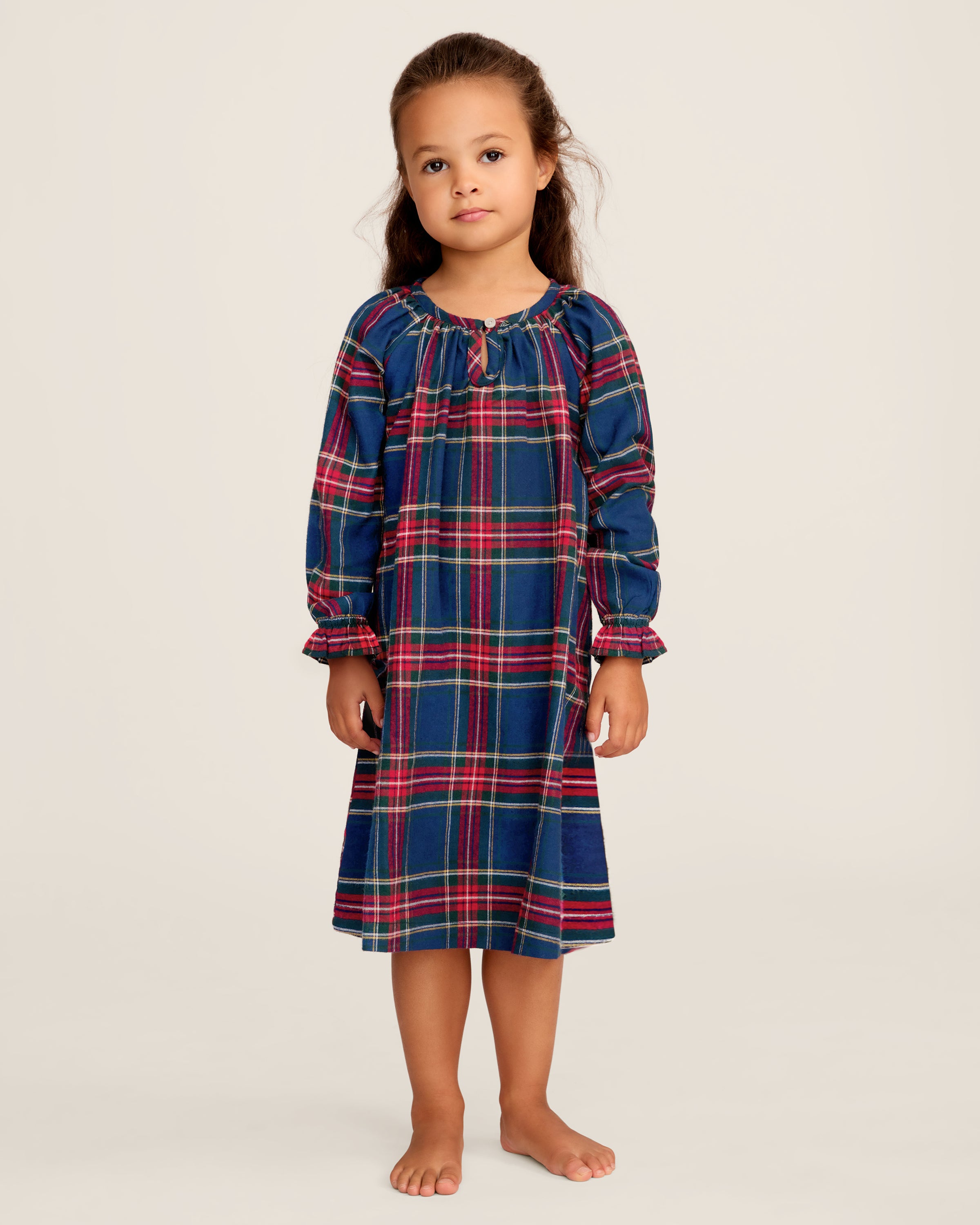 The Girl's Brushed Twill Delphine Nightgown in Windsor Tartan features a blue, green, and red plaid pattern, knee-length long sleeves with ruffled cuffs, and a round neckline with a small button.