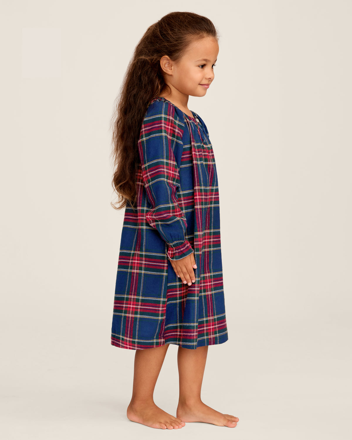 The Girl's Brushed Twill Delphine Nightgown in Windsor Tartan features a blue, green, and red plaid pattern, knee-length long sleeves with ruffled cuffs, and a round neckline with a small button.