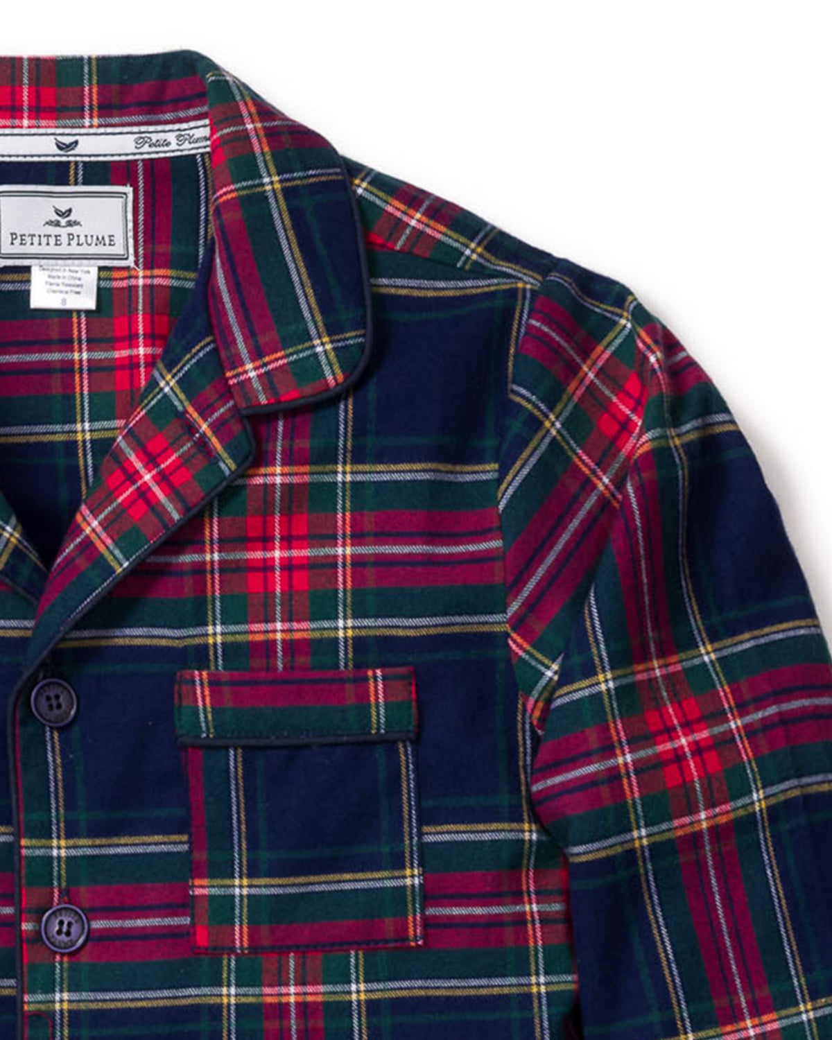 Close-up of the Kid’s Brushed Twill Pajama Set in Windsor Tartan, showcasing a plaid pajama top with red, green, navy, and yellow stripes, a chest pocket, and a Petite Plume label inside the collar.