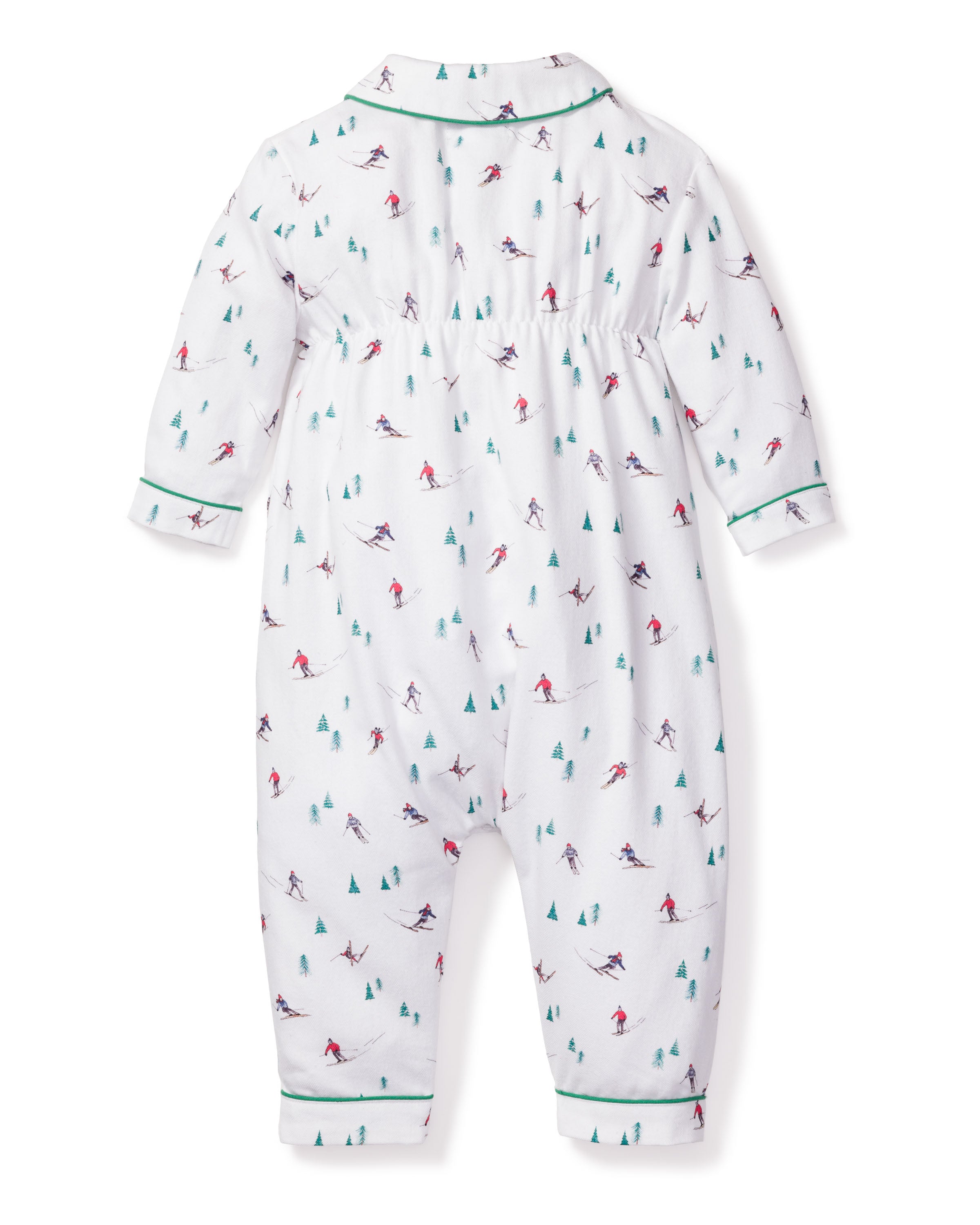 The Petite Plume Babys Flannel Cambridge Romper in Après Ski is a white long-sleeve romper with small skiers and green trees, featuring green piping on cuffs and collar. It is made from flame retardant fiber for safety and displayed flat to show the back view.
