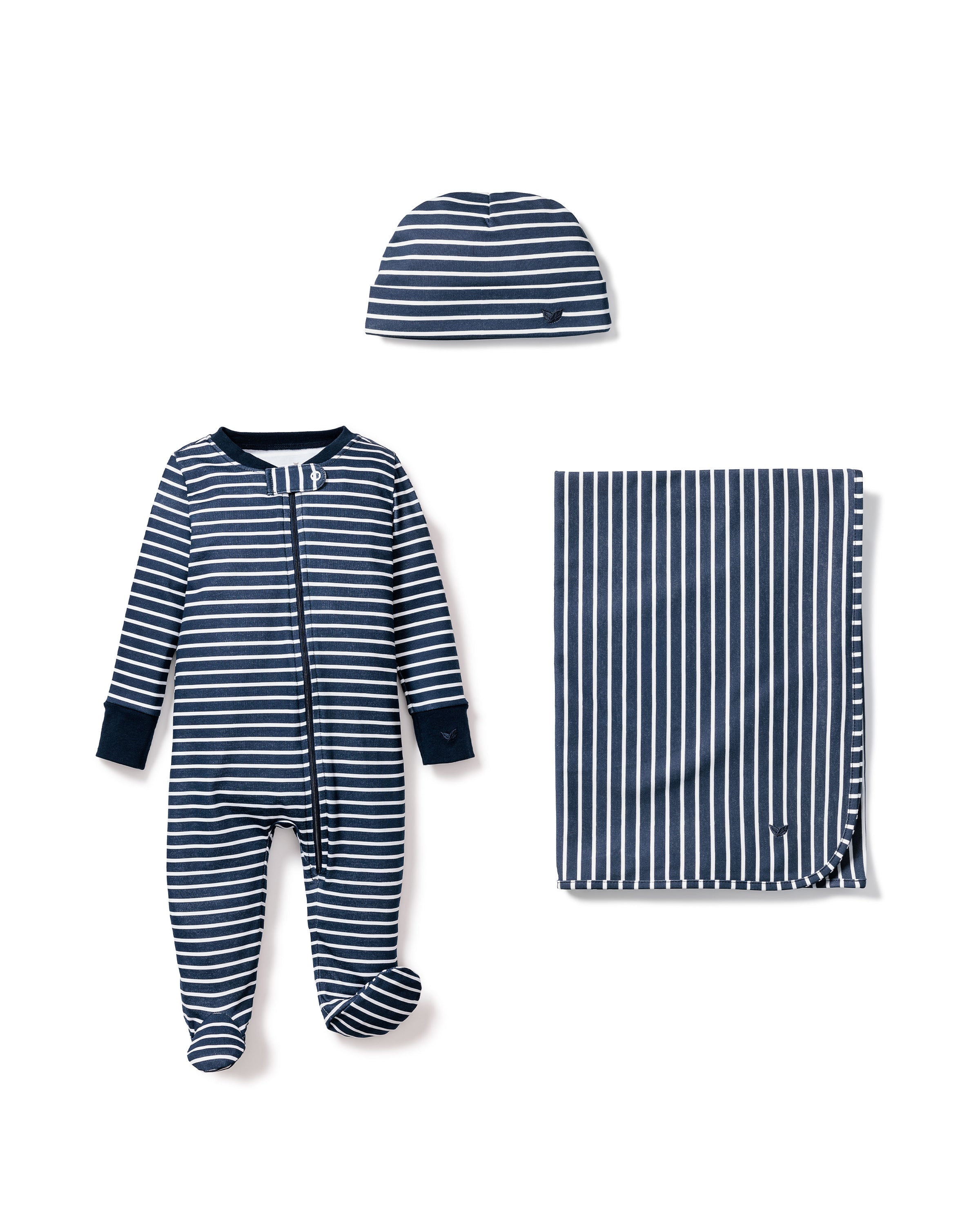 A Welcome Home Baby Set by Petite Plume, featuring navy blue and white stripes, includes a footed romper with a front zipper, a small beanie, and a cozy blanket. This luxurious set is styled neatly on a white background.