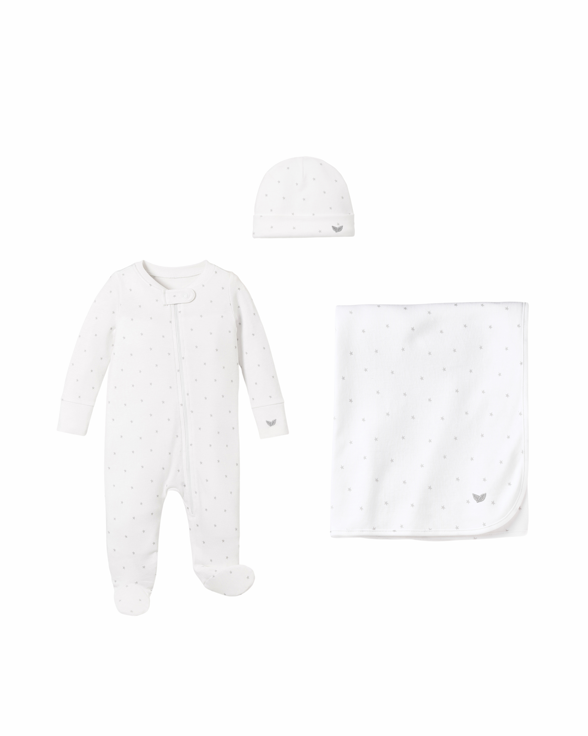 The Welcome Home Baby Set - Grey Stars by Petite Plume includes a white footed romper with subtle polka dots, a side zipper, matching beanie, and cozy blanket. A small dove emblem adorns each piece.