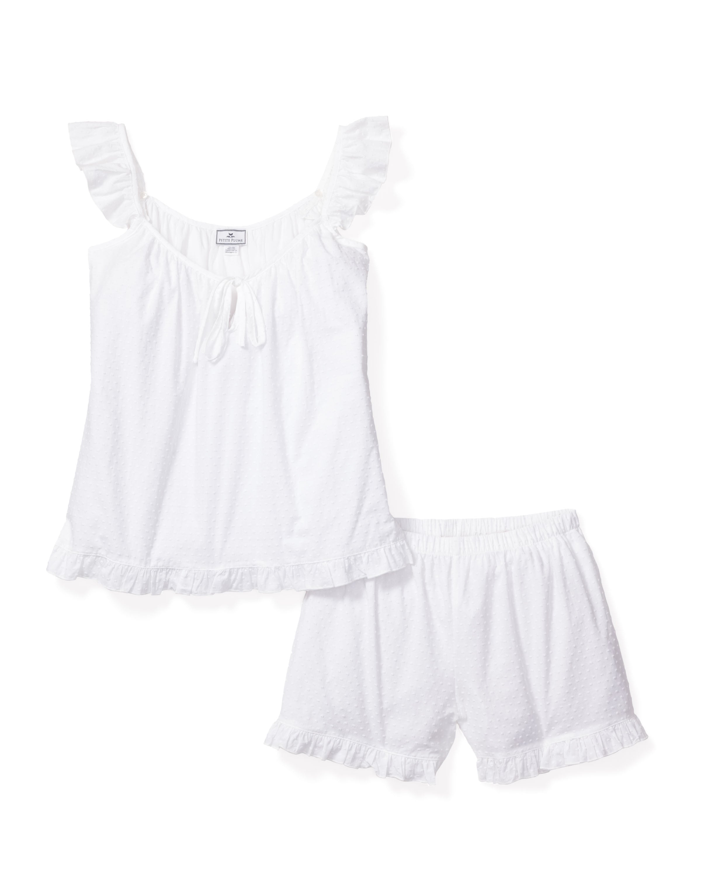 The Womens Swiss Dots Celeste Short Set in White by Petite Plume features a sleeveless cotton top with ruffled straps and a bow, paired with matching shorts. Delicate ruffles adorn the edges, completing this charming ensemble.
