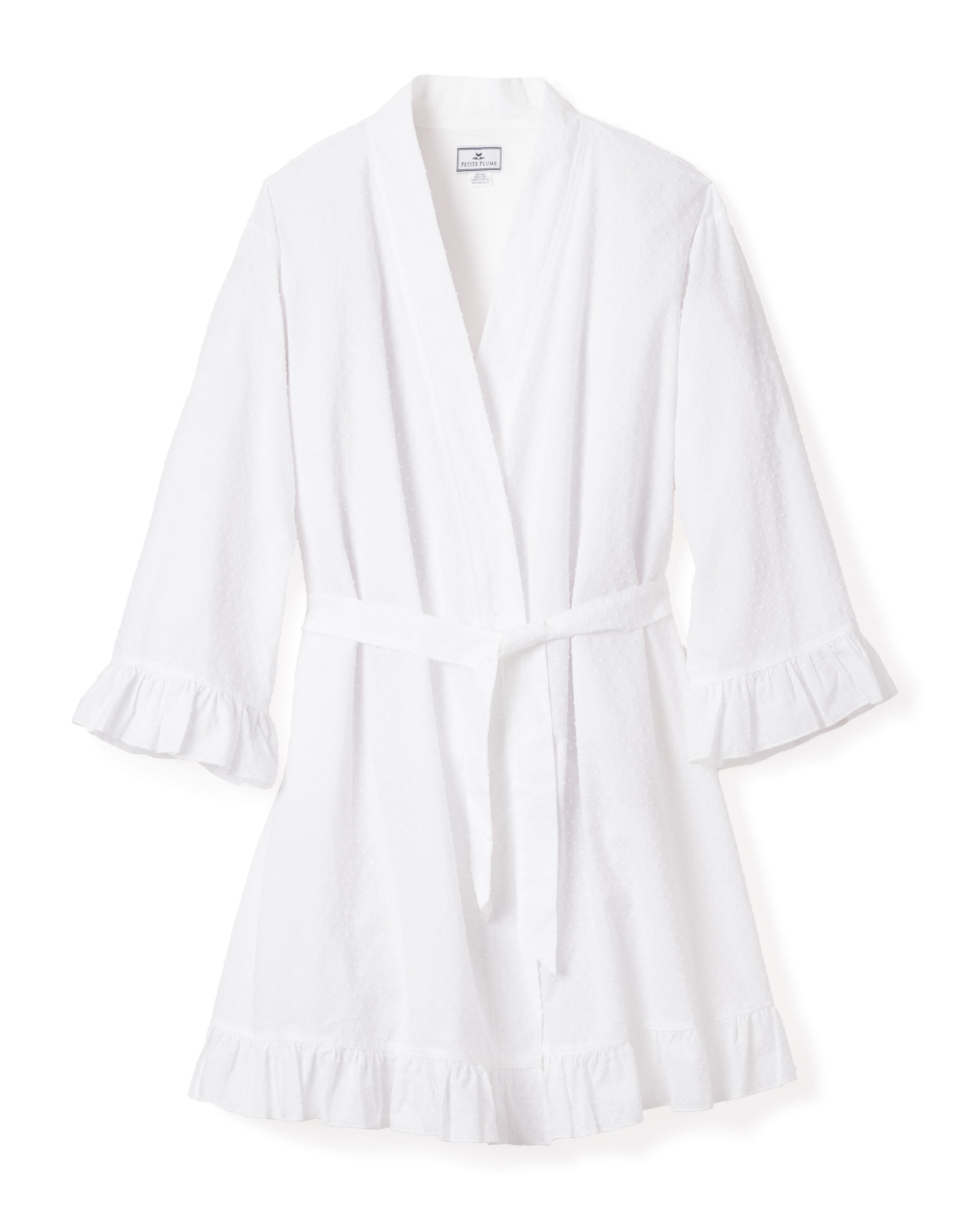 The Womens Swiss Dots Robe in White by Petite Plume features three-quarter sleeves, a textured finish with Swiss Dots, and ruffled hems and cuffs. It includes a matching waist belt for a relaxed fit and is crafted from quality cotton ensuring ultimate comfort, making it a summer classic.