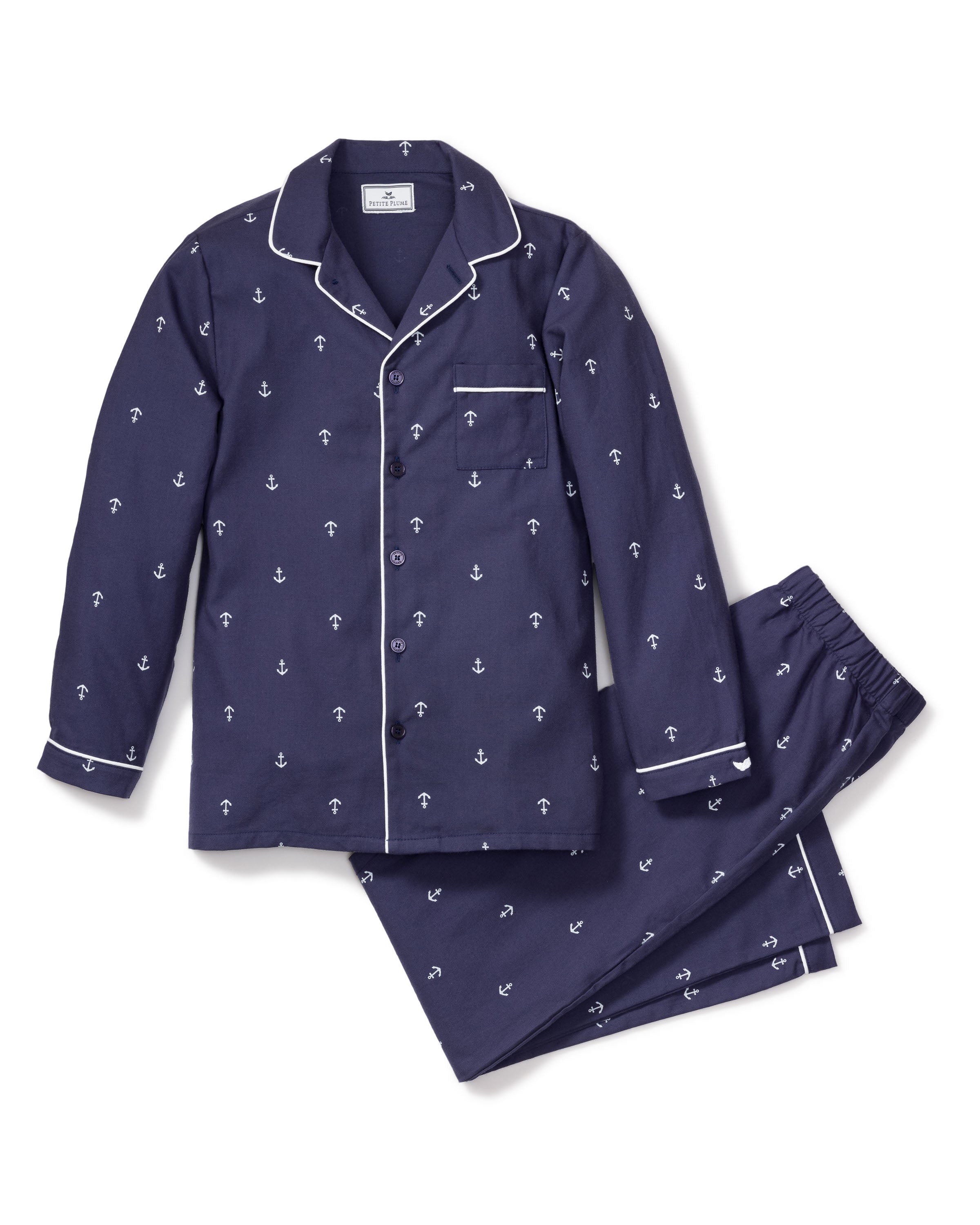 Experience luxury with the Kids Twill Pajama Set in Portsmouth Anchors by Petite Plume. This navy set features an anchor pattern with white piping, a button-front long-sleeved top, chest pocket, and pants with an elastic waistband for comfort.