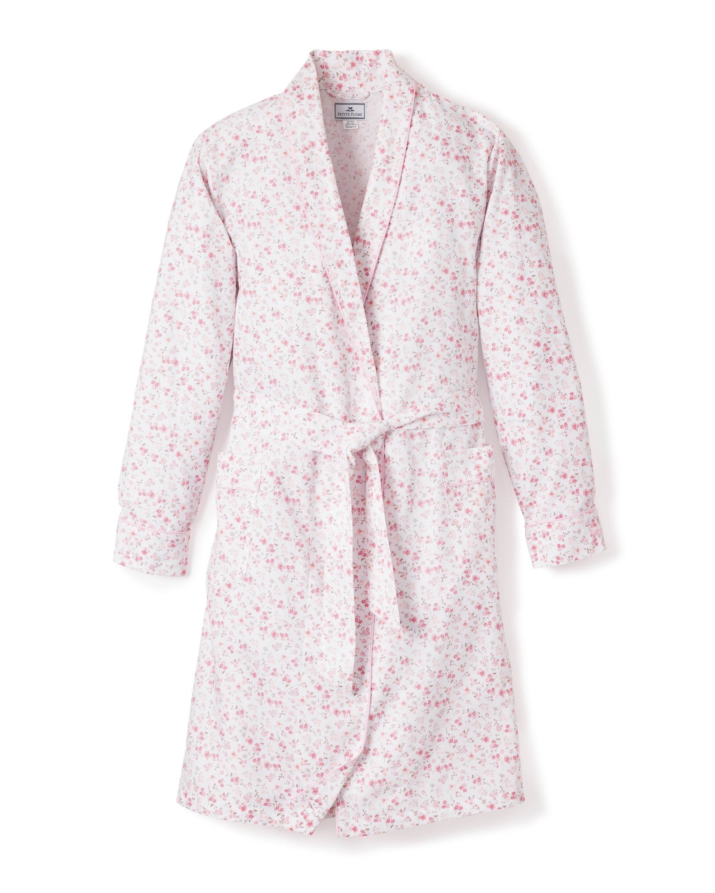 The Womens Twill Robe in Dorset Floral by Petite Plume offers luxurious sleepwear with an elegant white floral design featuring pink and red flowers, a shawl collar, and a waist tie, crafted from the finest quality cotton.
